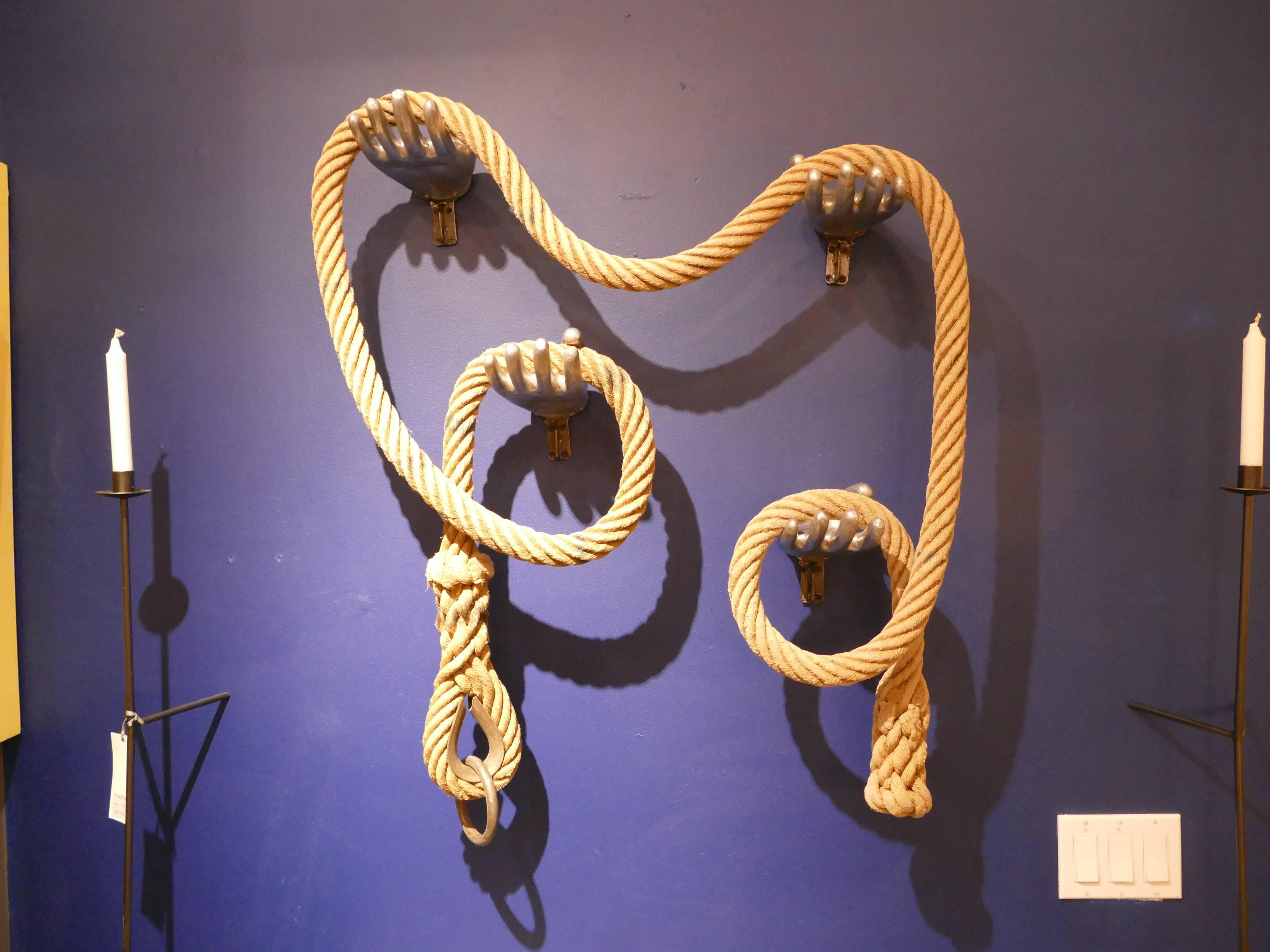 Created from four vintage aluminium glove molds and a vintage gymnasium rope, we have created this unique wall sculpture. The rope can be moved to endless configurations. I unique look. The rope and molds are from the 1940s.