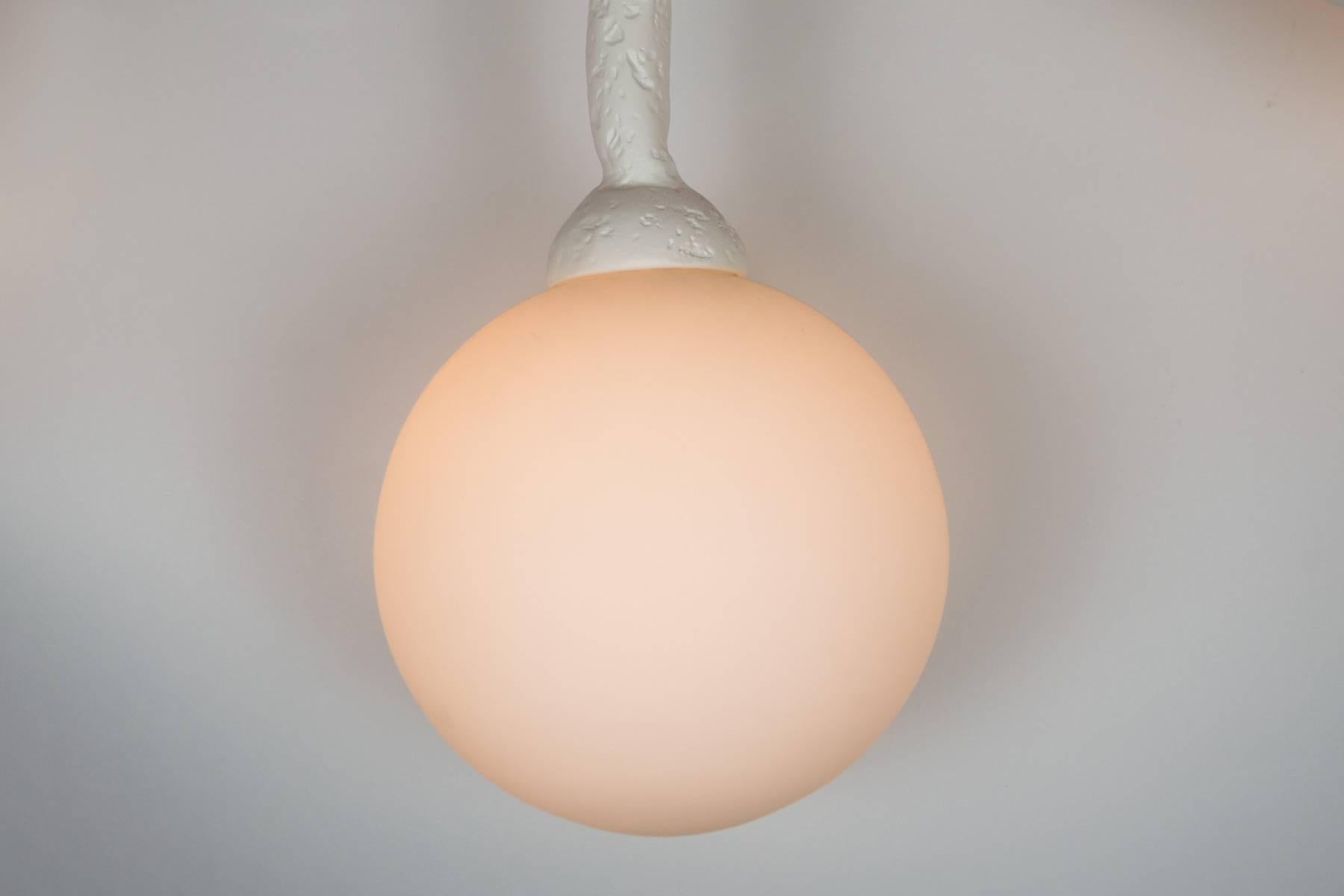 This unique chandelier has a plaster of Paris finish on it organic design frame.  The light has 16 opaline glass diffusers.  Light uses 16 candelabra base bulbs.  Max wattage 40 each socket.  