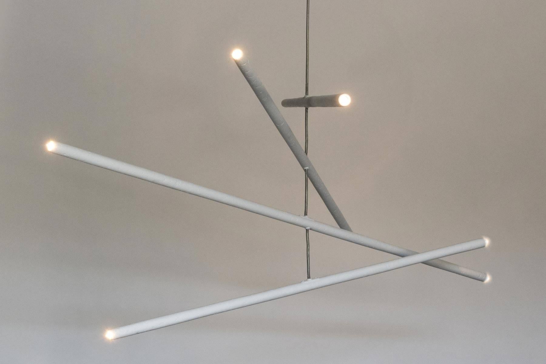 This intriguing chandelier floats in the air like a mobile. The hand finished plaster rods are fitted with voltage halogen sockets and are suspended from a stainless steel wire. The eight lights provide a perfect ambience and light the room with a