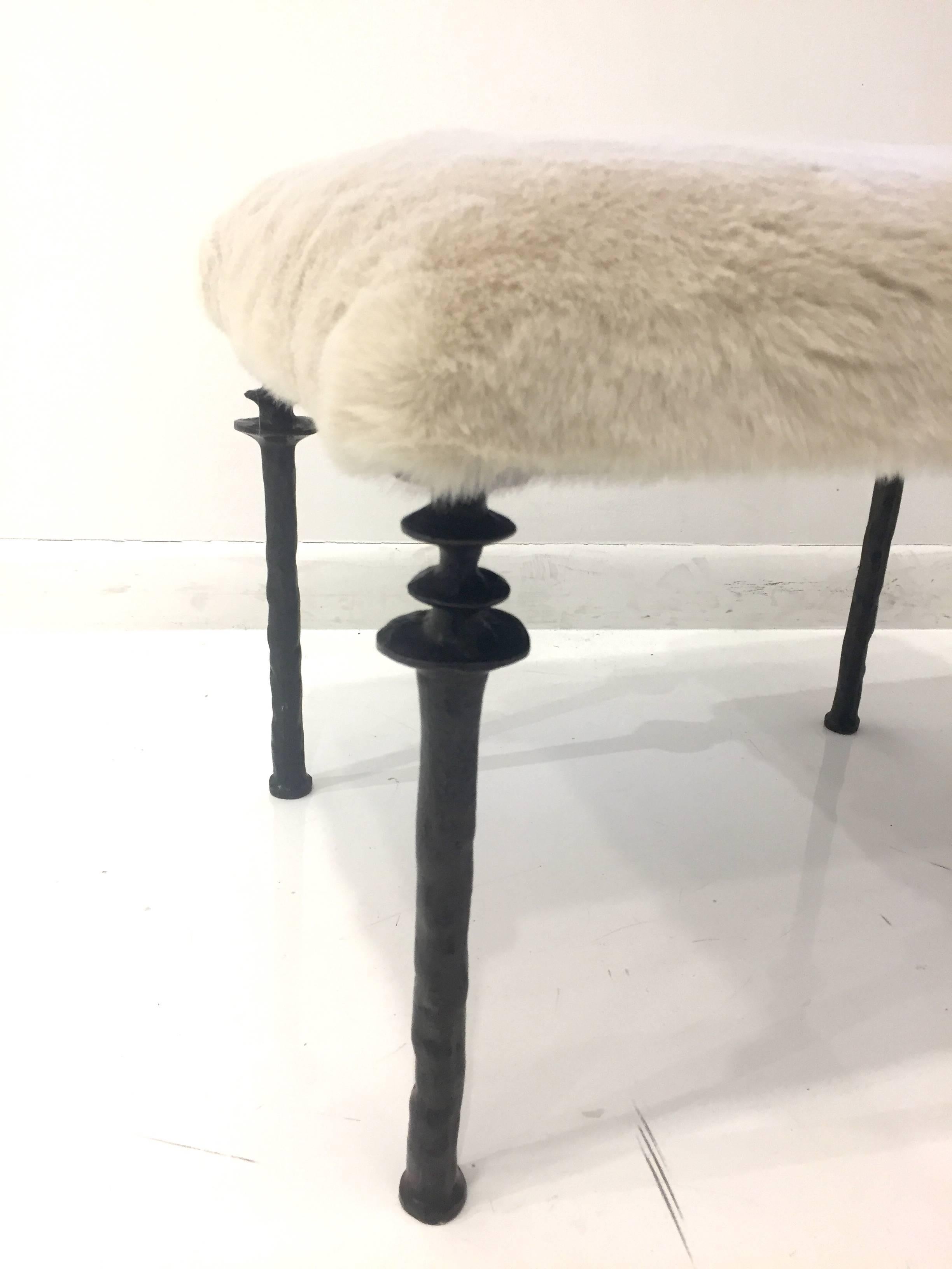 Two beautiful stools inspired by Diego Giacometti, these stools are ideal for
those who are looking for unique seating. Their cast bronze legs provide
a truly organic touch. The seat cushion has been upholstered in an off white faux fur. 