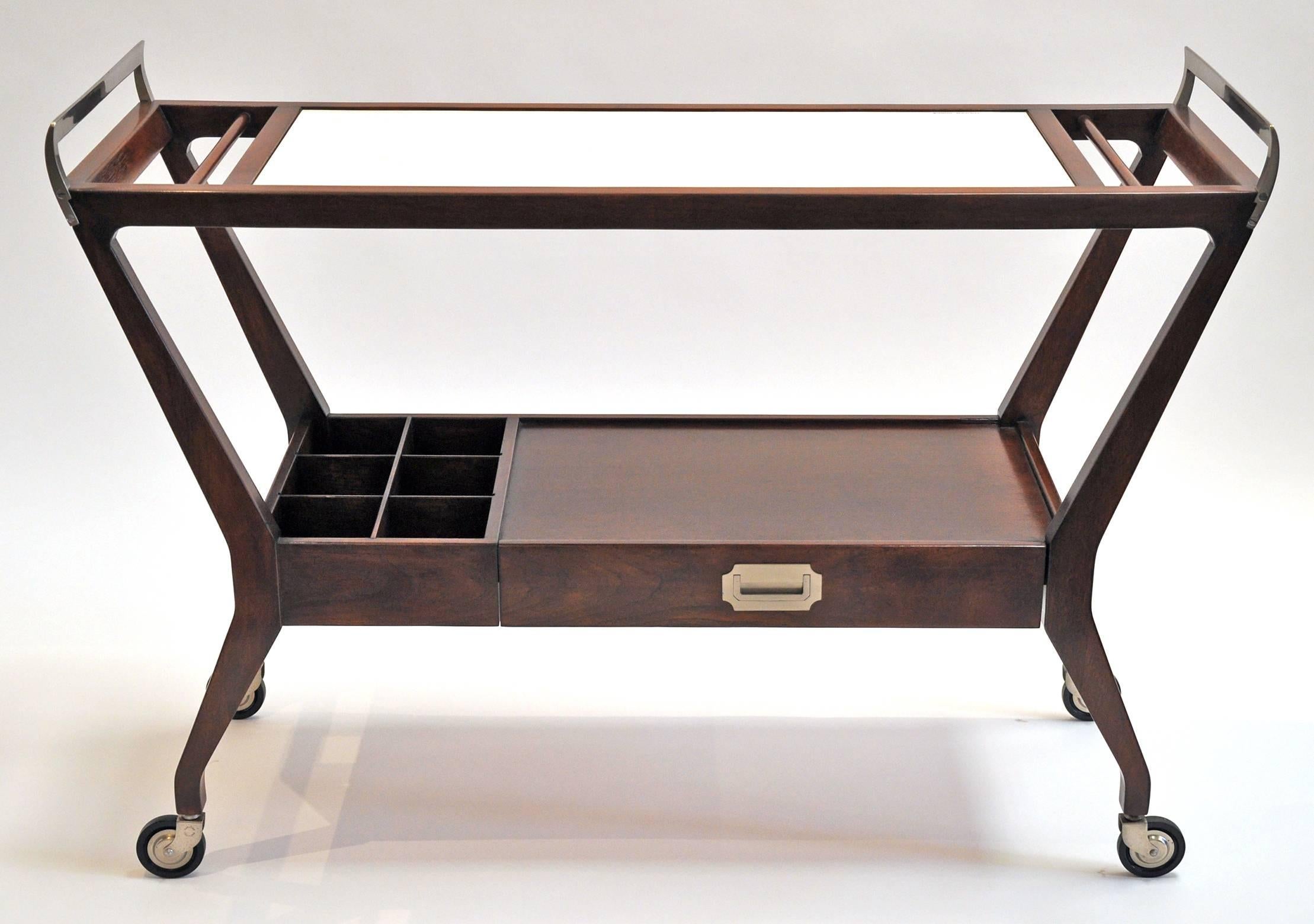 Bar cart or serving cart made by Baker Furniture Company. Finished walnut frame features a white laminate top, six bottle decanter holder, storage drawer and wheels. The handles and drawer pull are polished steel. The top shelf is 32