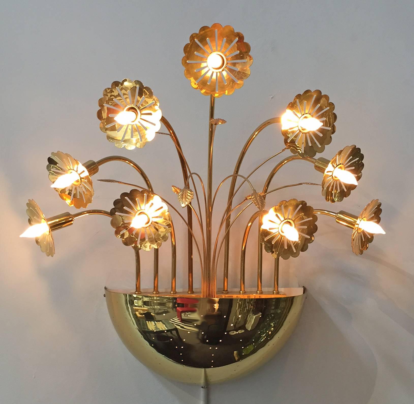 Wall light designed by Finnish modern master of lighting: Paavo Tynell. 
Made of brass with perforated illuminated bowl and nine flowers with bulbs. This is an exceptional piece. The finish has been expertly restored and the wiring is new. Ready