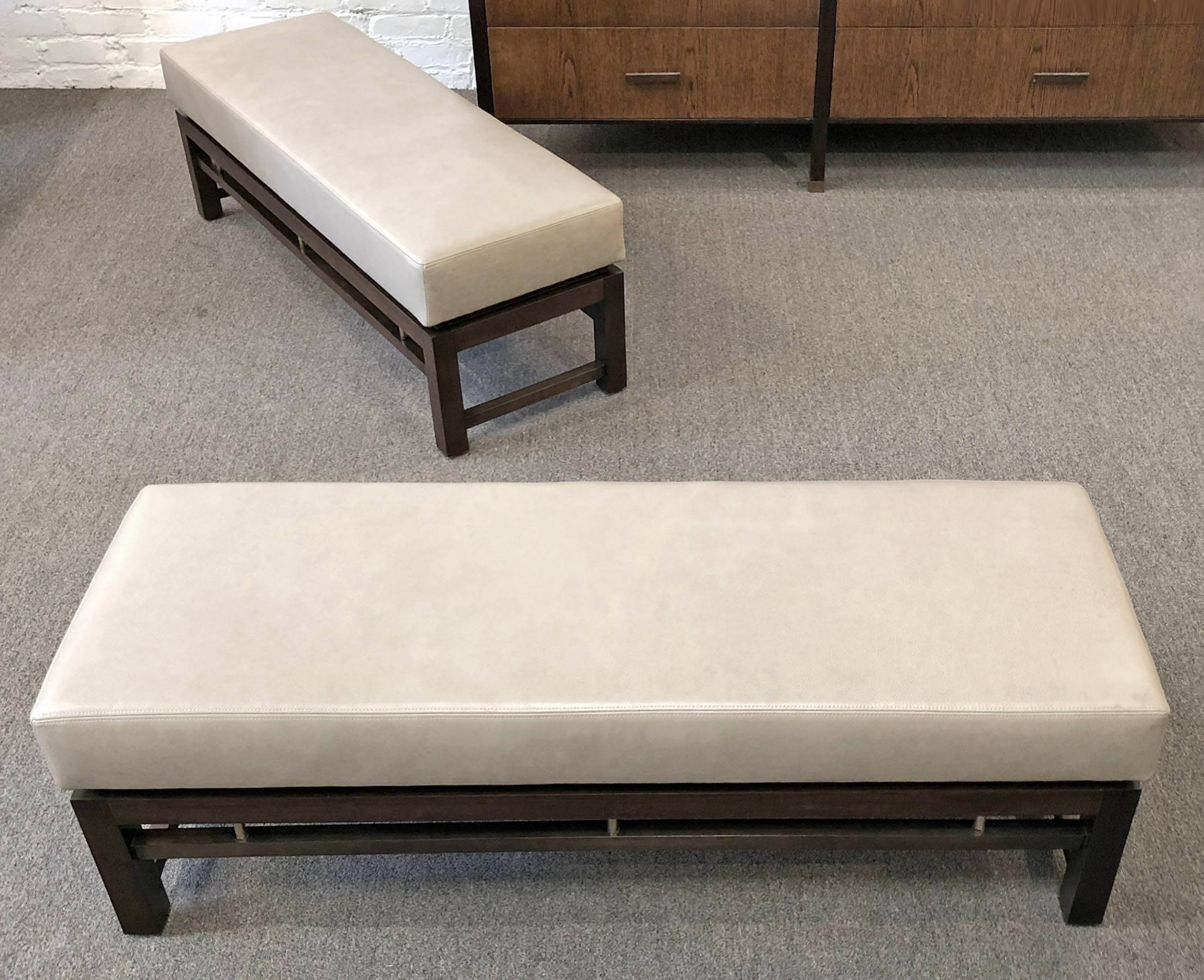 Pair of upholstered benches designed by Edward Wormley for Dunbar Furniture Company. Features finished walnut frames, brass details and leather upholstery. Price is for the pair. Ready for use.