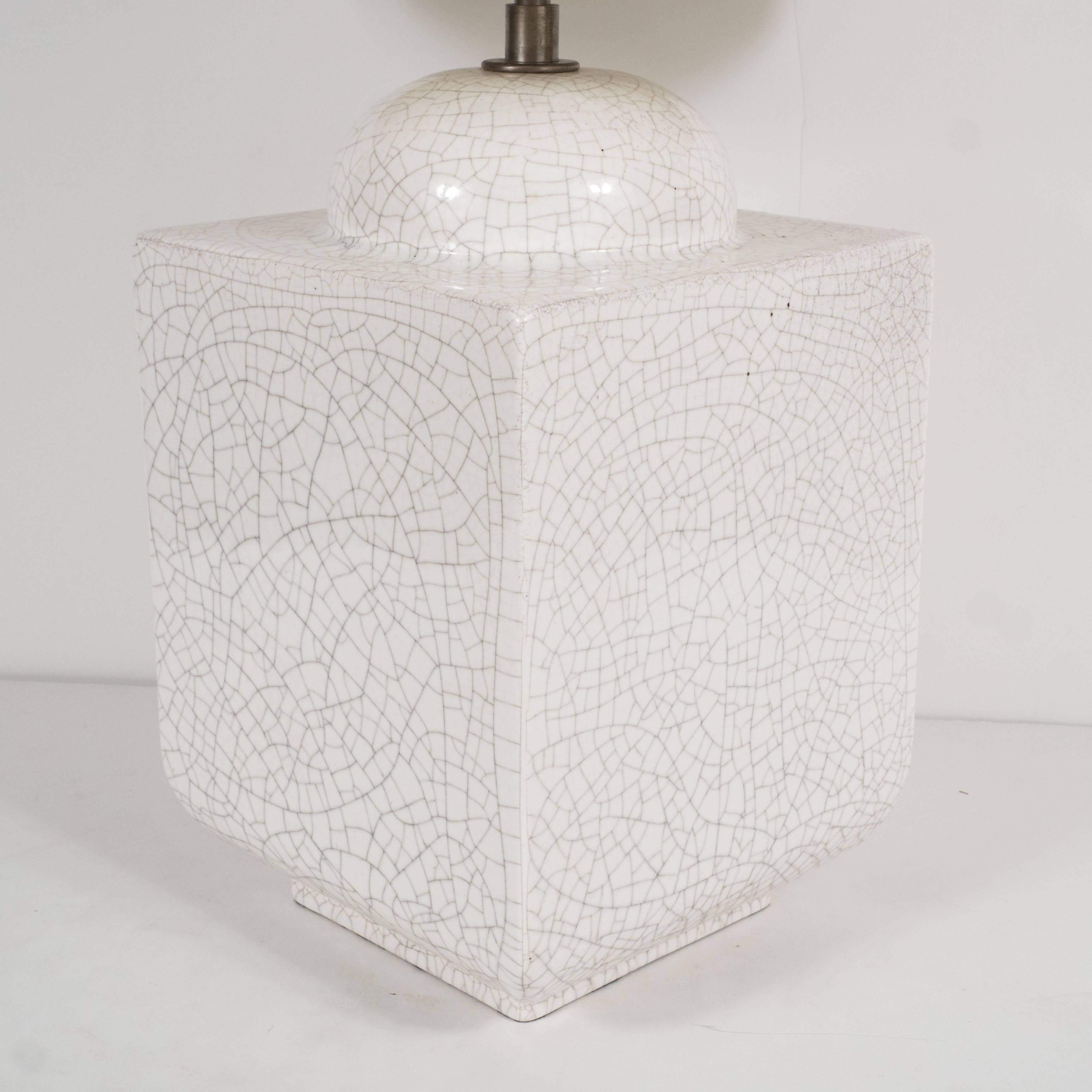 A square molded ceramic table lamp, with a cream crackle glaze.
    