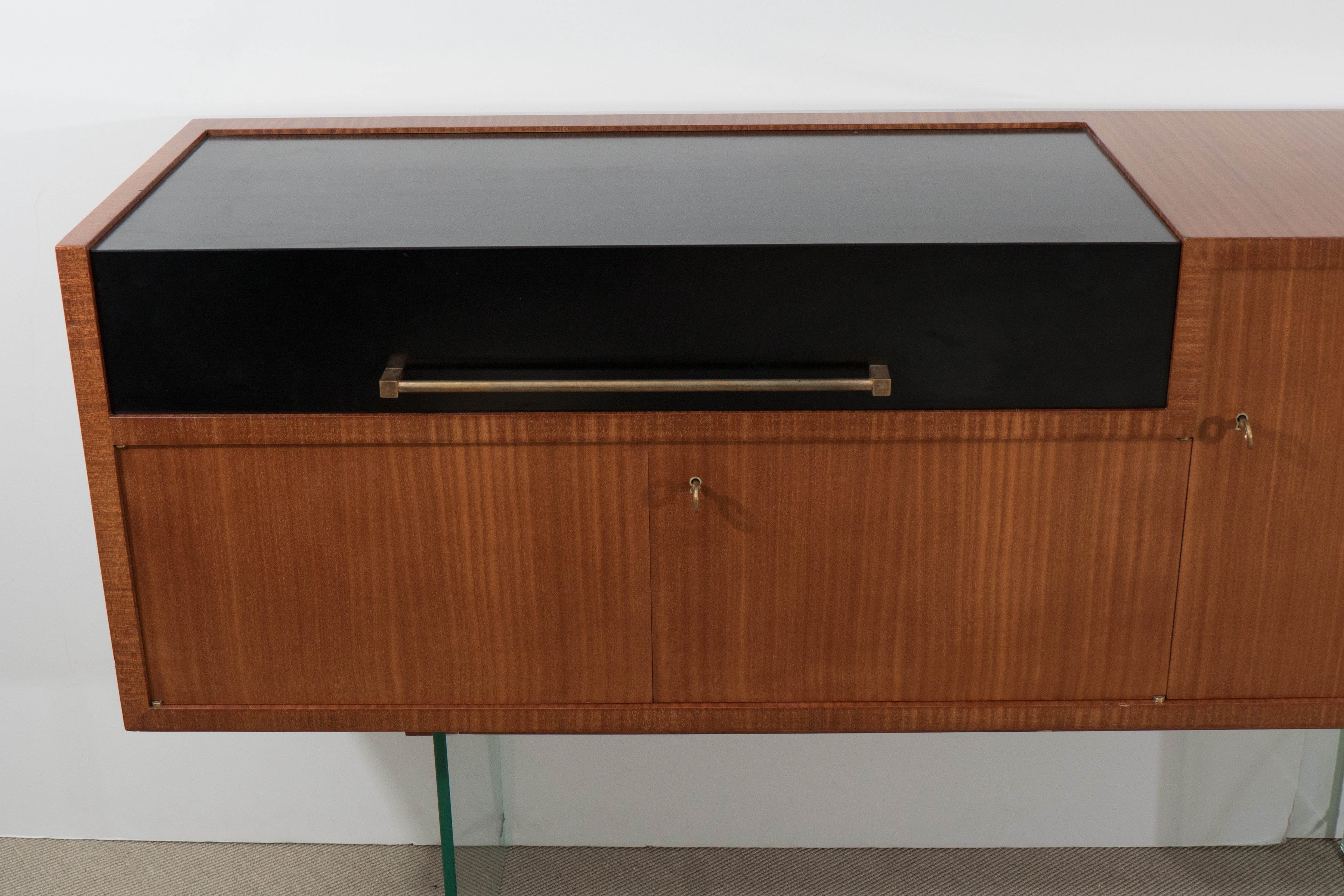 Jacques Dumond ‘attributed’ bar console with glass supports, France, circa 1950, with top opening compartment and lower shelves with doors.