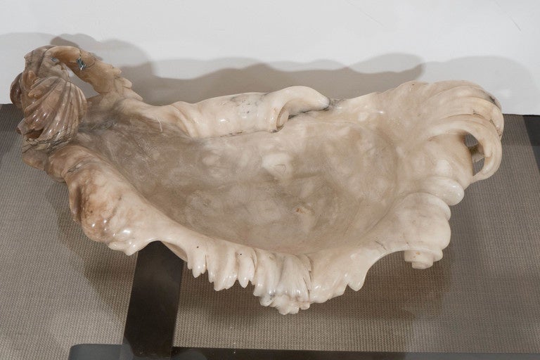 A large 19th century Italian alabaster bowl with baroque wave and scrolled carving.