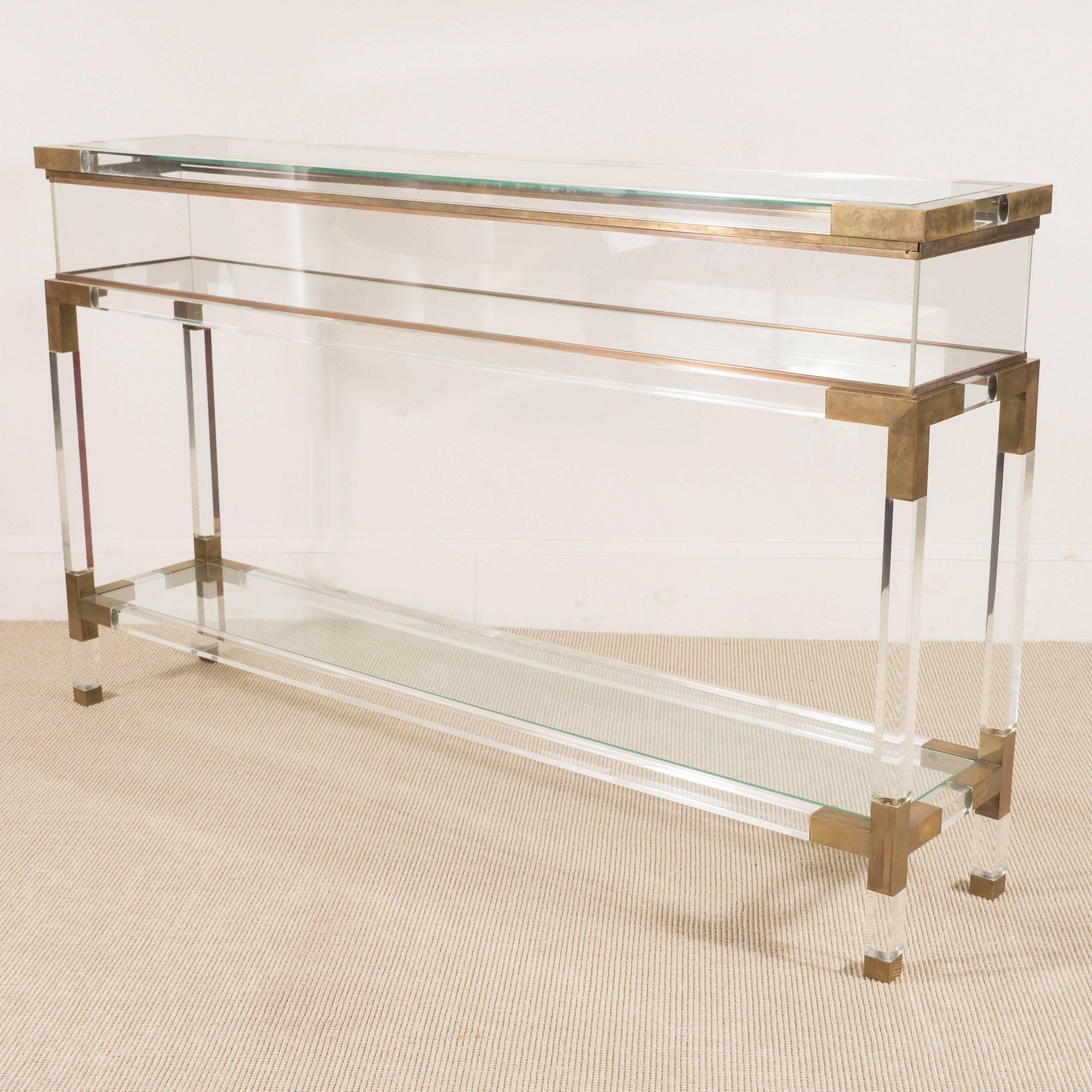 Lucite console/vitrine with glass shelves and brass details, France, circa 1960.