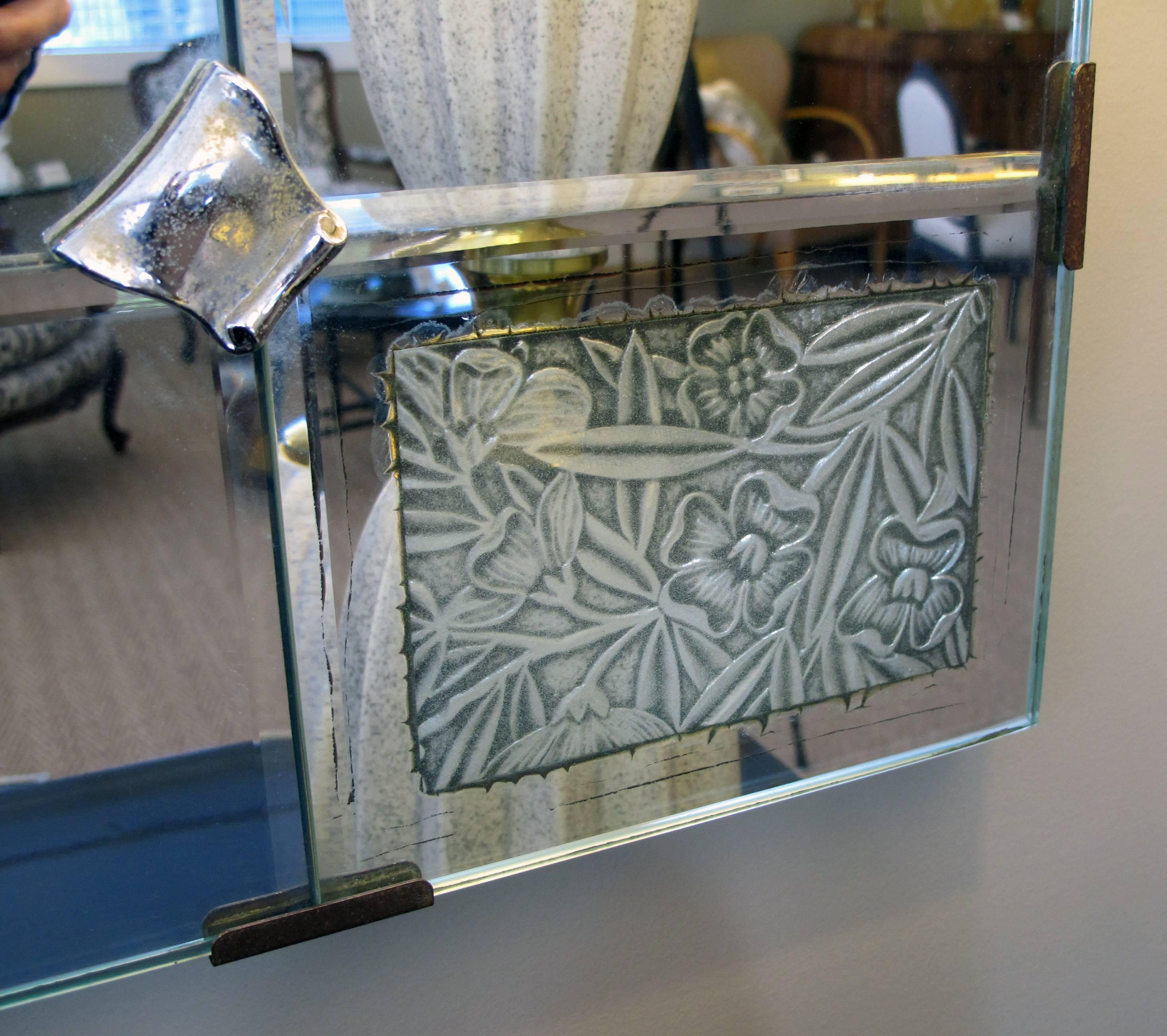 A large and good quality French Art Deco beveled mirror with pewter floral reserves; may be hung vertically or horizontally; the large rectangular bevel plate within beveled mirror borders with inset pewter panels at the corners.