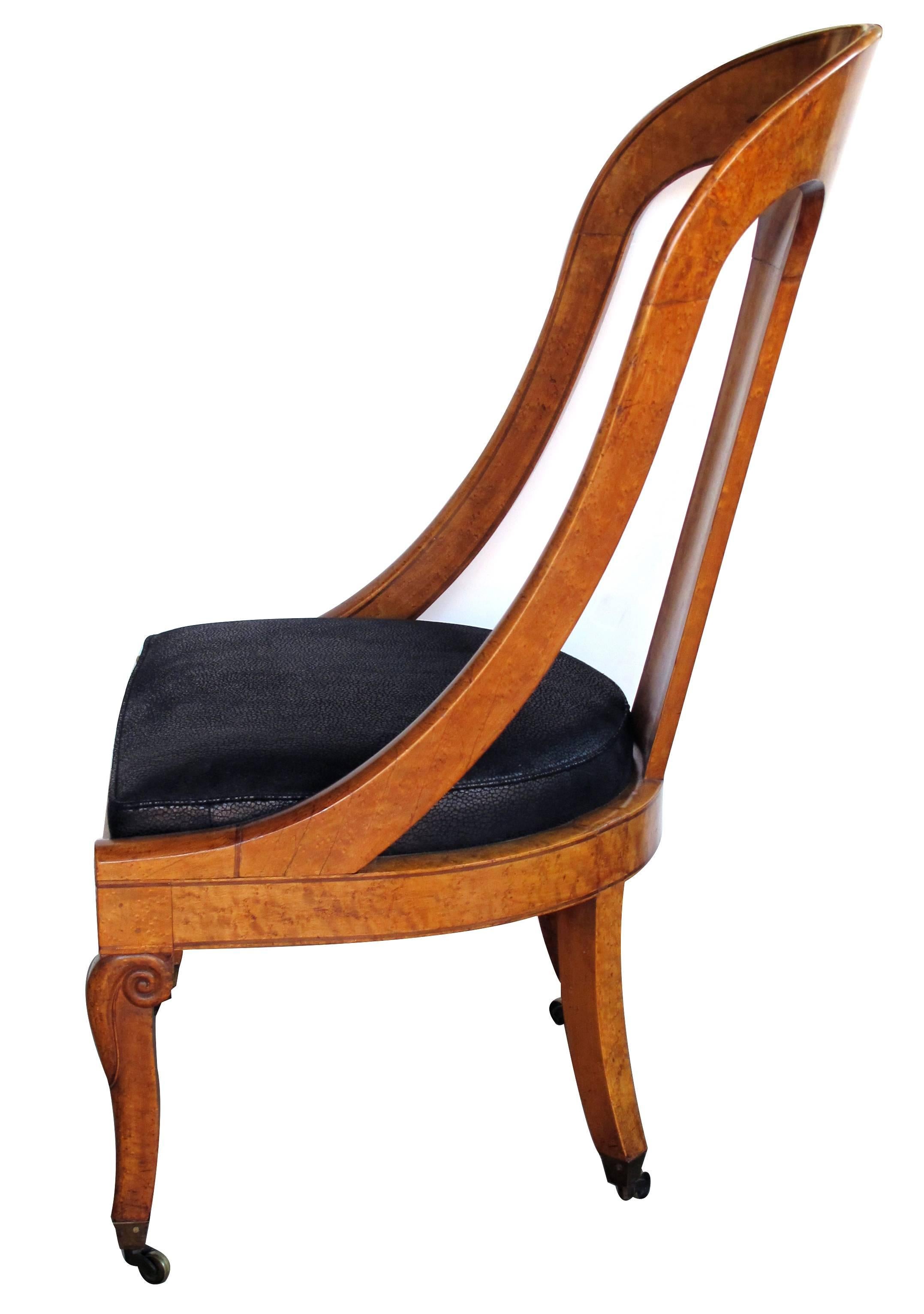 Belle chaise française Charles X à dossier en cuillère en ronce de bouleau ; le haut dossier incurvé est orné d'un bandeau floral et feuillagé stylisé ; les accoudoirs sont inclinés vers le bas ; l'assise est caissonnée et repose sur des pieds en
