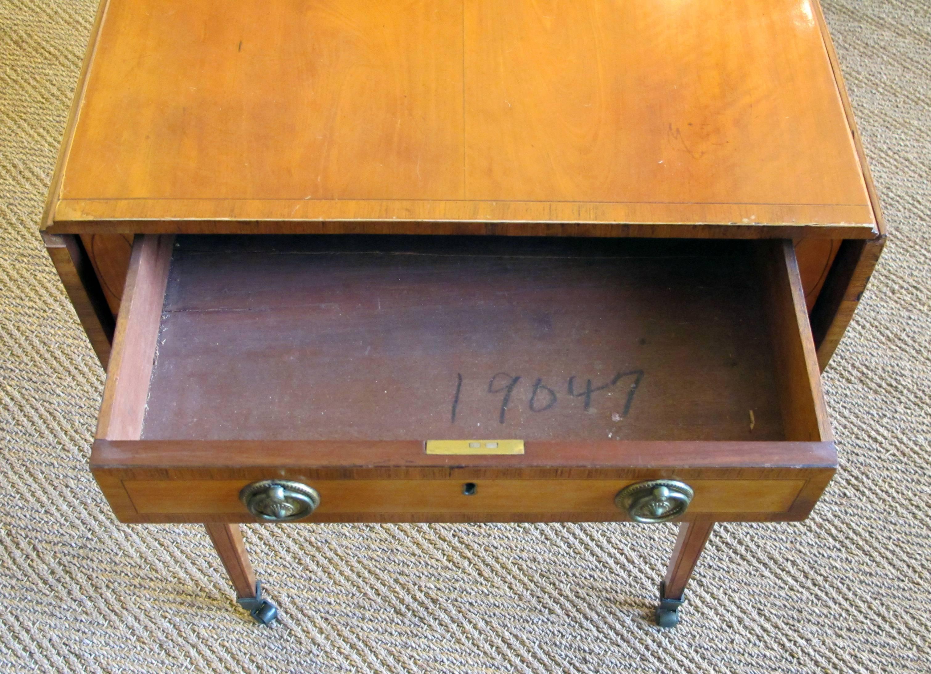 A fine English George III satinwood single-drawer D-end Pembroke table with kingwood inlay and ebony stringing, in the manner of Thomas Sheraton, the rectangular top with D-end flaps all with kingwood crossbanding, fitted with a single drawer with