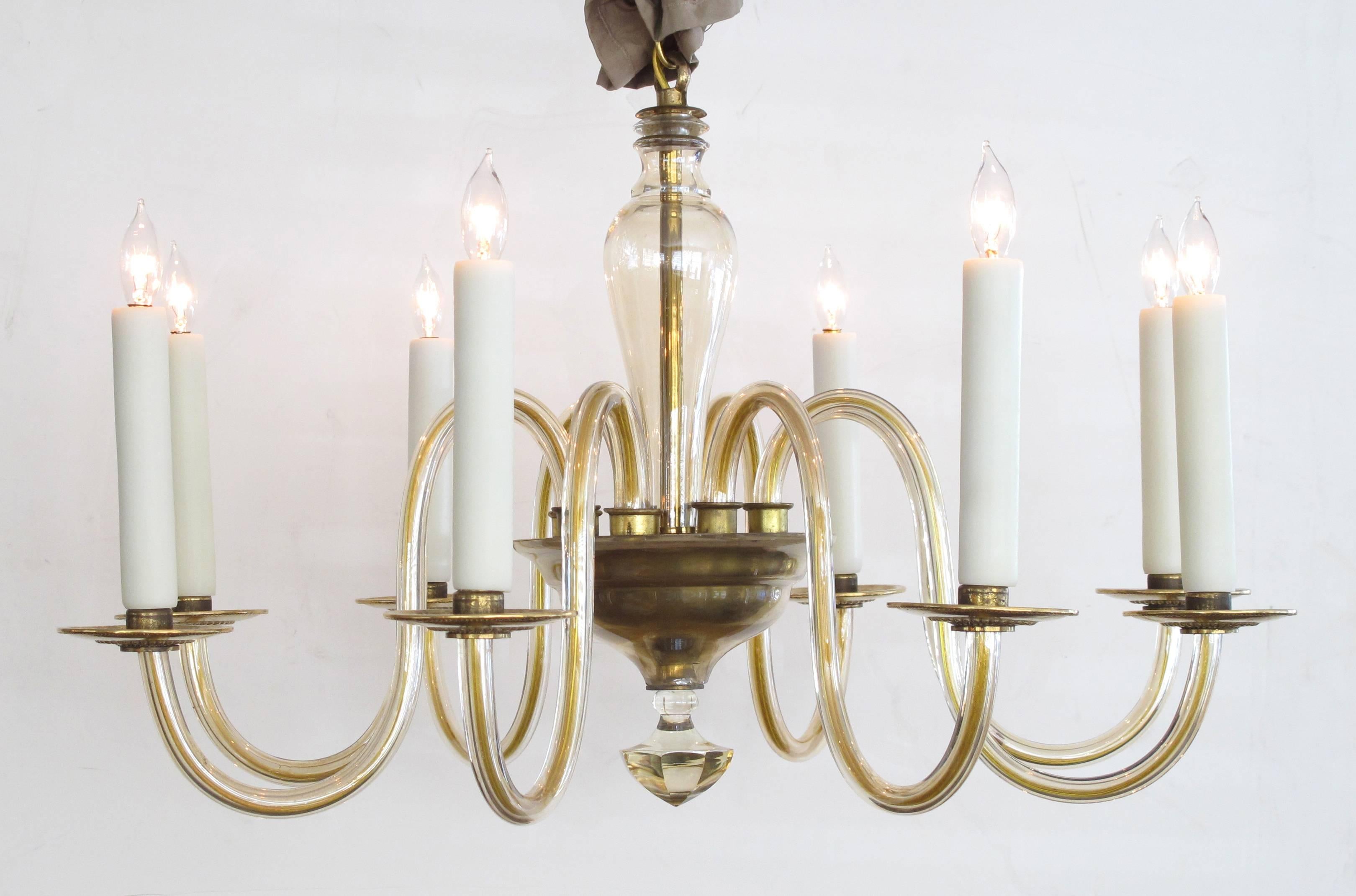 A shapely Murano 1950s pale gold glass eight-light chandelier; the baluster support surrounded by eight deeply scrolled arms joining a bowl with faceted pendant.