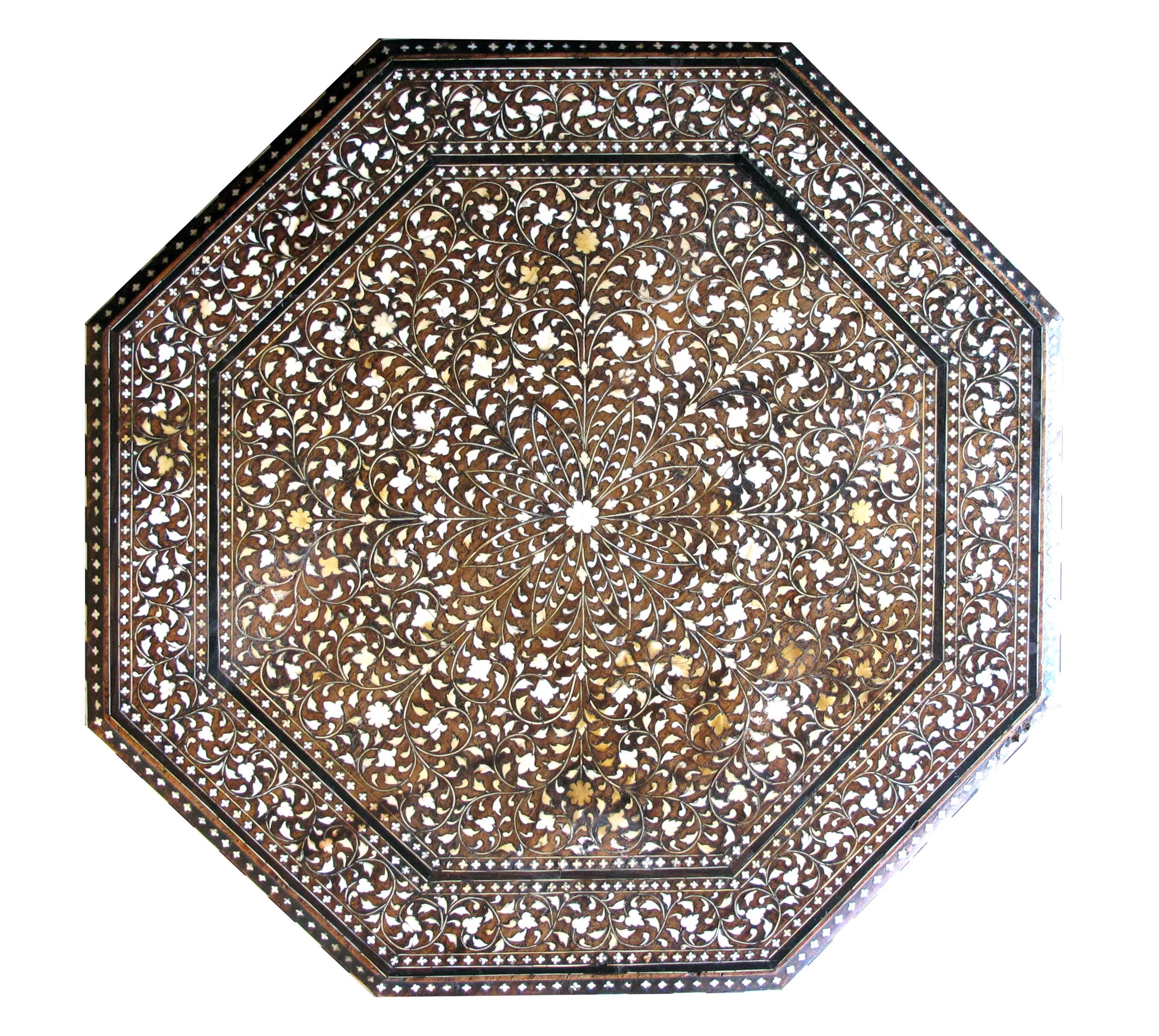 An unusually large and intricately inlaid Anglo-Indian octagonal traveling table; the octagonal top centering an inlaid medallion within a foliate band; raised on arabesque supports; top now affixed.