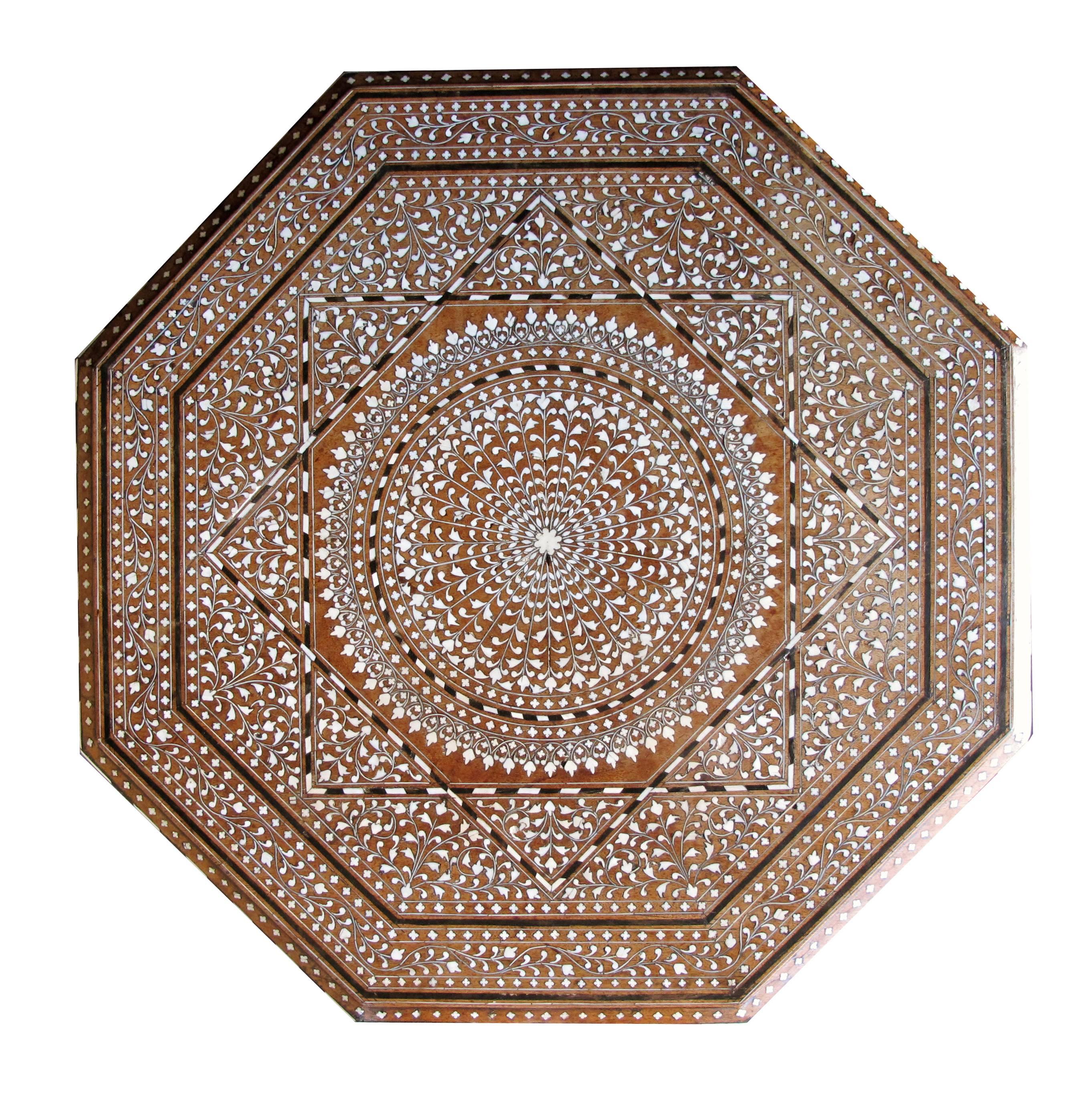 An unusually large and finely inlaid Anglo-Indian octagonal traveling table; the octagonal top centering an inlaid star medallion within a foliate band; raised on arabesque supports; top now affixed to base.