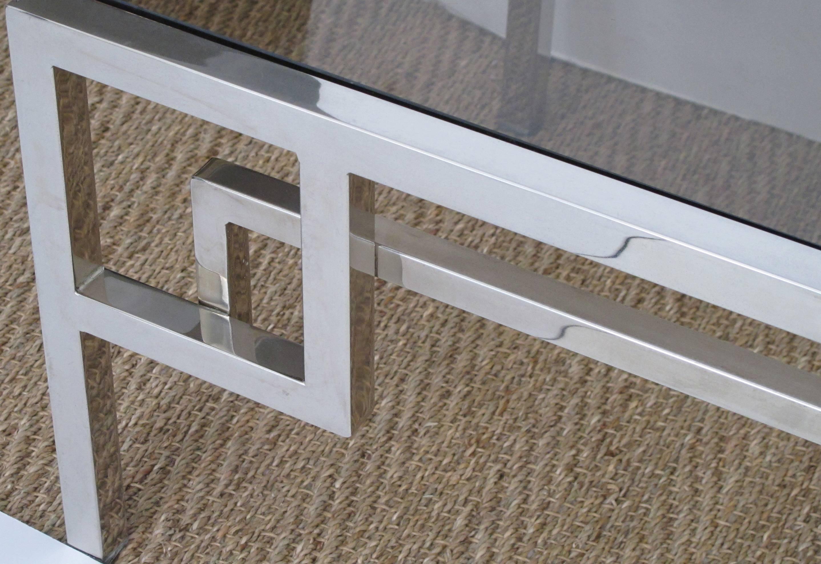 Table basse rectangulaire en chrome et verre des années 1970 ; le plateau en verre est inséré dans un cadre chromé avec un tablier géométrique ajouré.