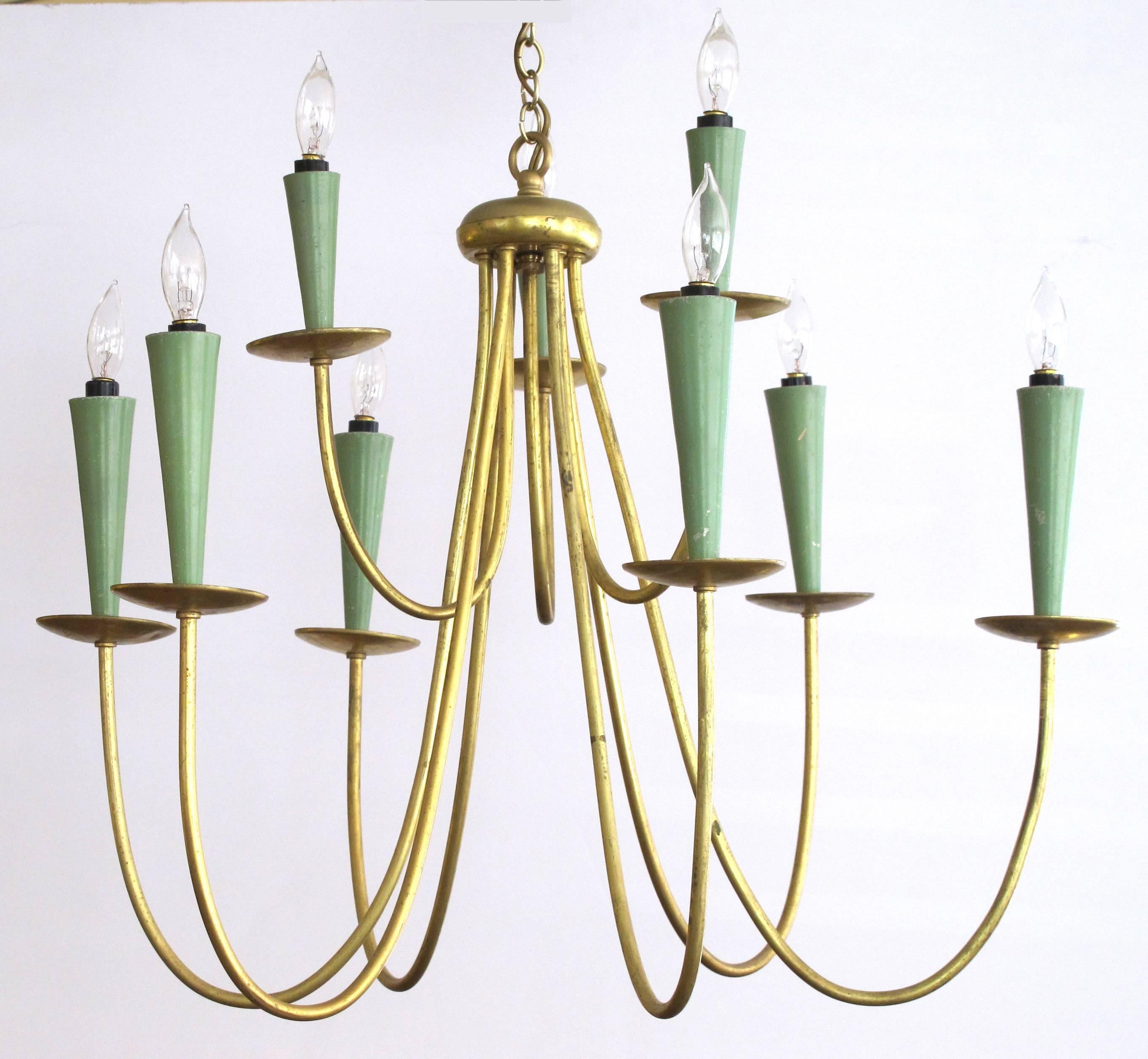 A chic Italian gilt and painted metal nine-arm chandelier; the central hub supporting nine swooping gilt-metal arms ending in gilt-metal bobeches and green-painted conical-shaped candle sleeves.
