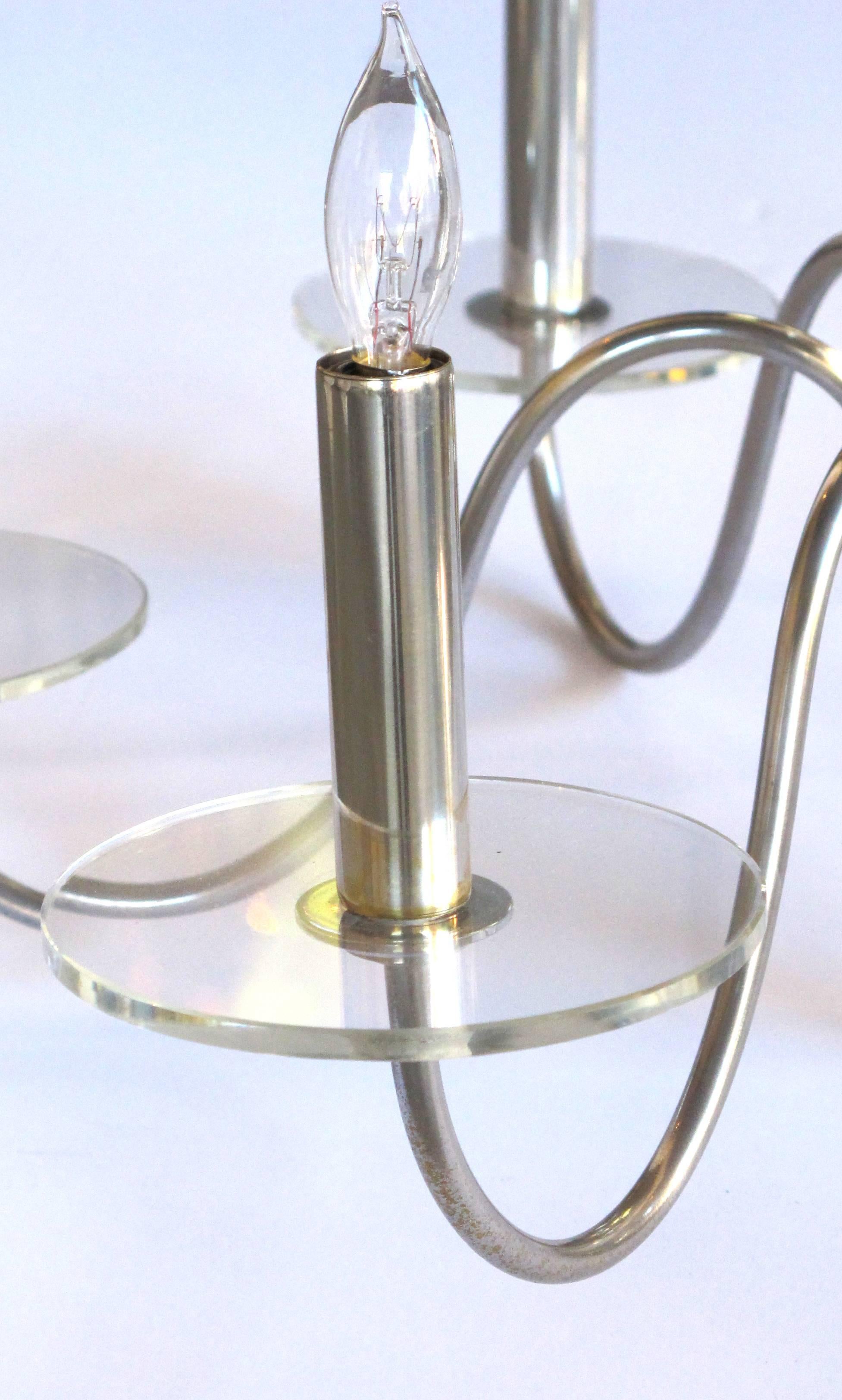 Un lustre Art Déco français brillant et élégant à six lumières chromées avec des sphères de verre empilées ; attribué à Jacques Adnet ; les supports centraux des orbes de verre gradués émanant tous de six bras de bougie profondément enroulés avec