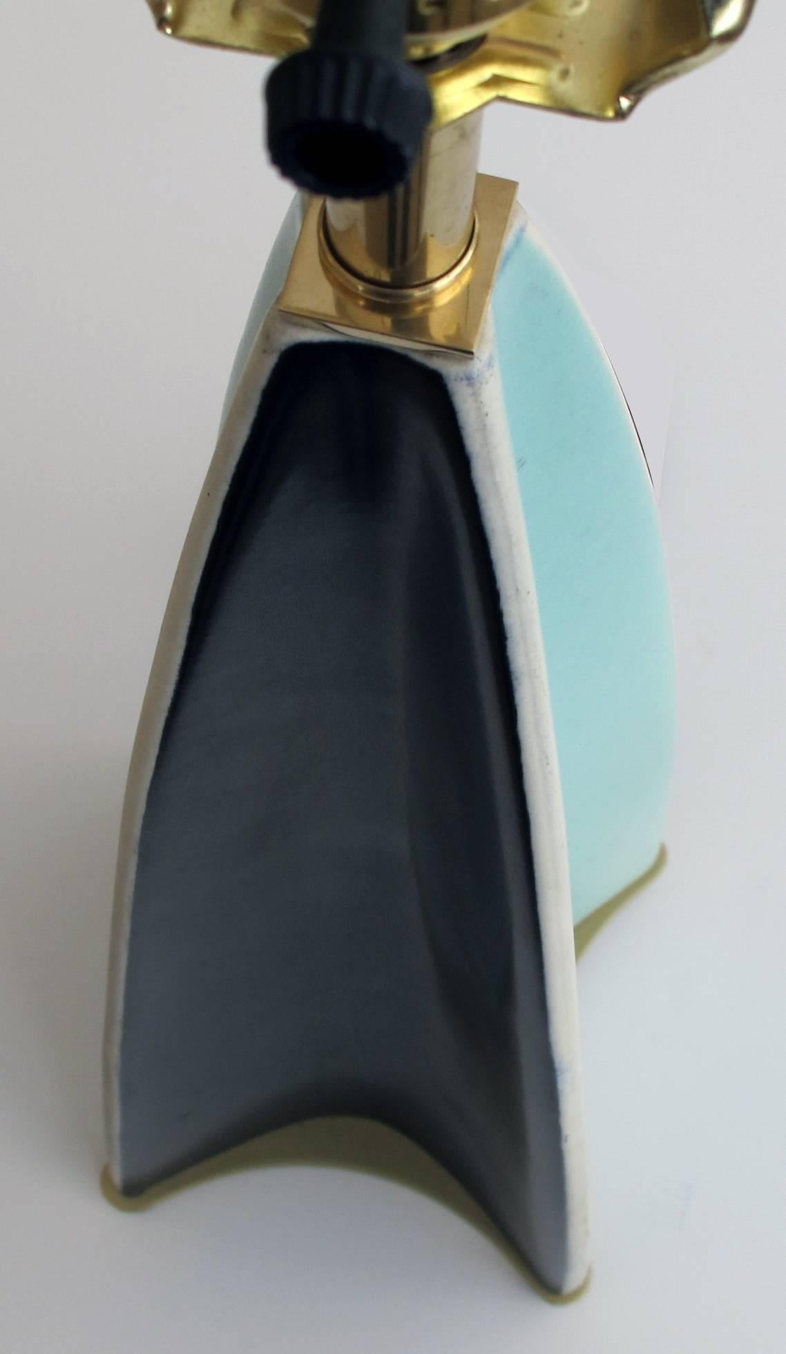 A stylish and rare pair of Gerald Thurston for Lightolier parabolic fin lamps each mod lamp of graduated quadrangular form with concave sides in black and aqua all raised on brass feet.