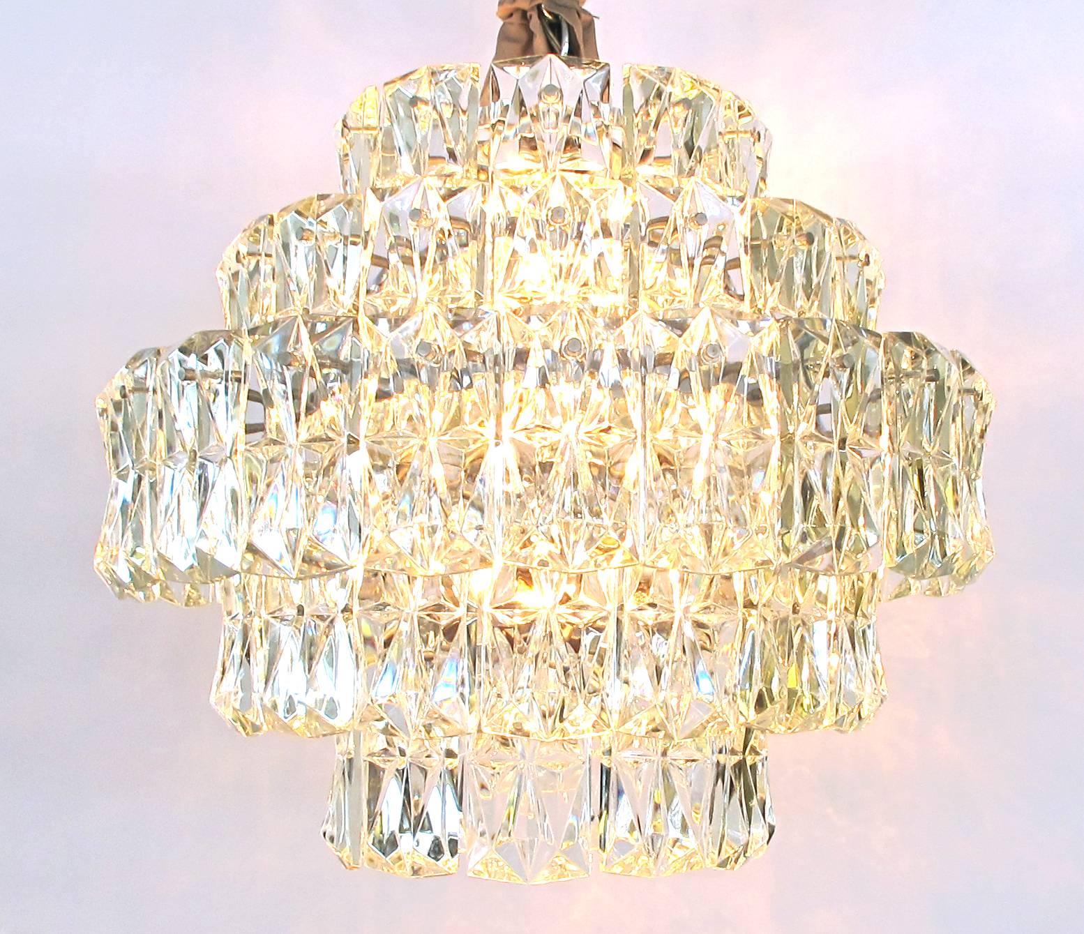 A striking German 1960s Kinkeldey Lighting five-tier chandelier with polished chrome frame and molded crystals; this shimmering Mid-Century Modern five-tier chandelier with its rectangular faceted crystals by Kinkeldey Lighting, Bad Pyrmont, Germany.