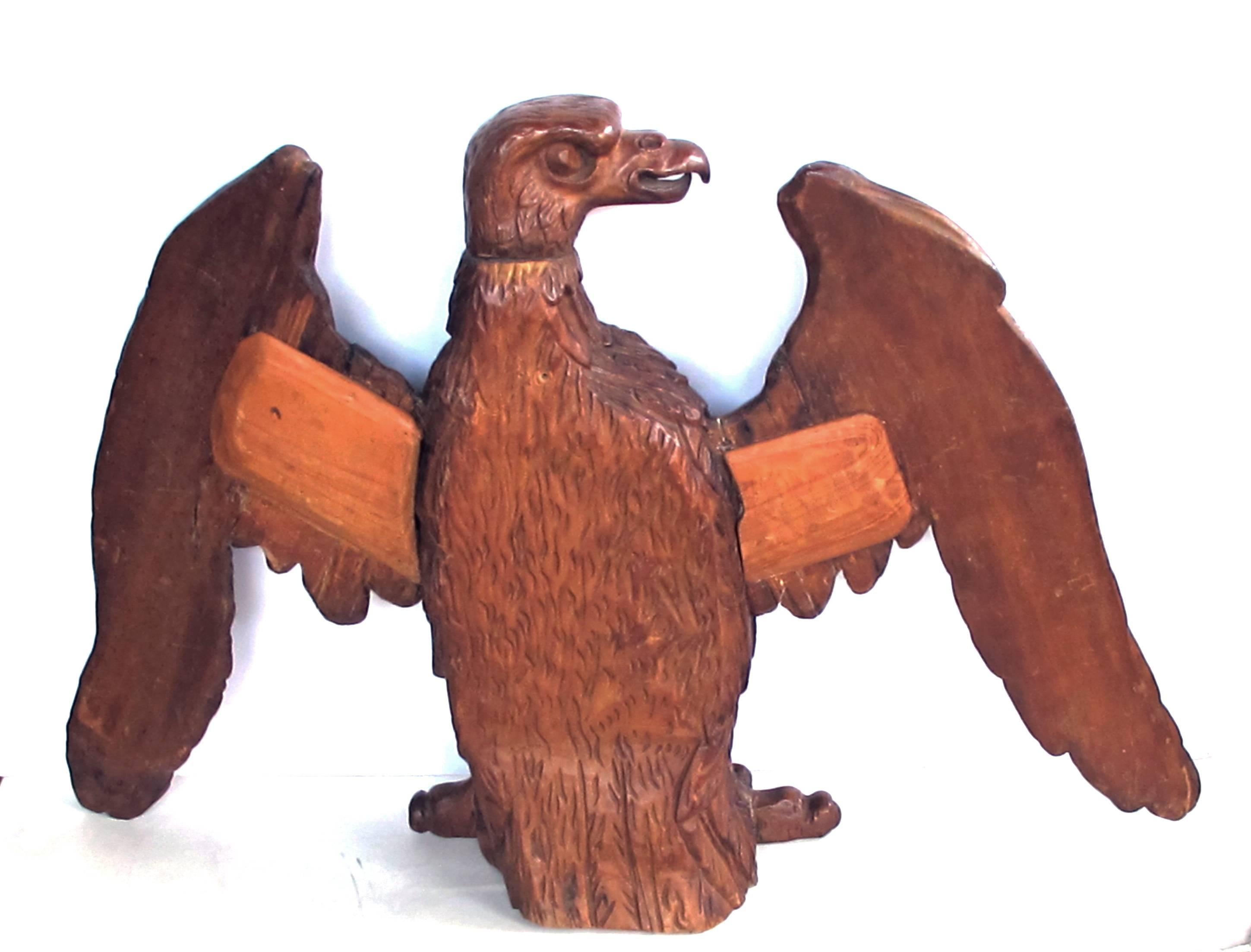 An exceptional and robust American 19th century Folk Art wood carving of an American eagle; of bold proportions with head in profile above a strong body and legs; with wings outstretched.