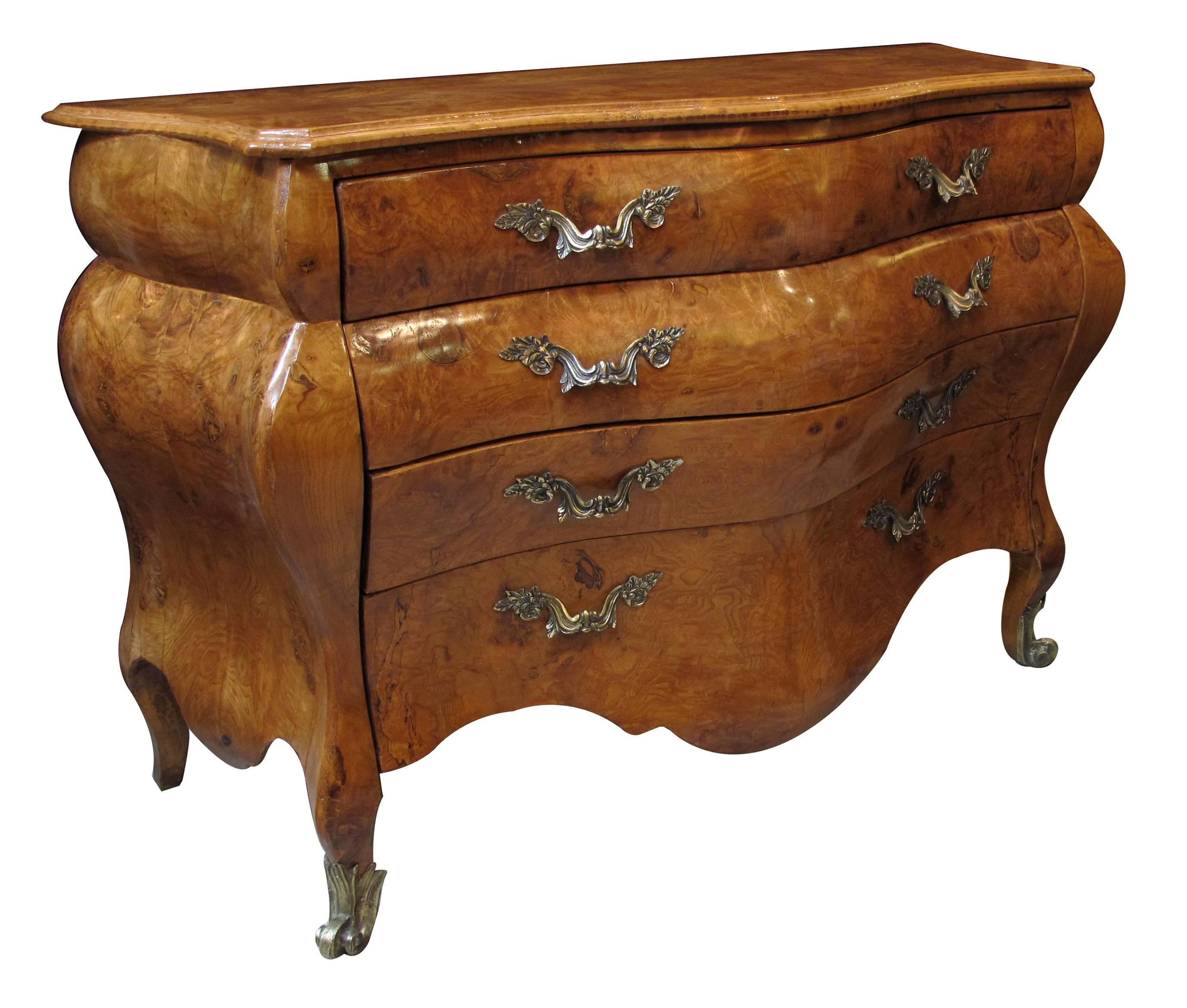 A shapely and large-scaled Italian rococo style olive wood bombe-form four-drawer chest; the serpentine top above a conforming curvaceous body fitted with 4 drawers above a deeply scalloped apron; raised on short cabriole supports with scrolled