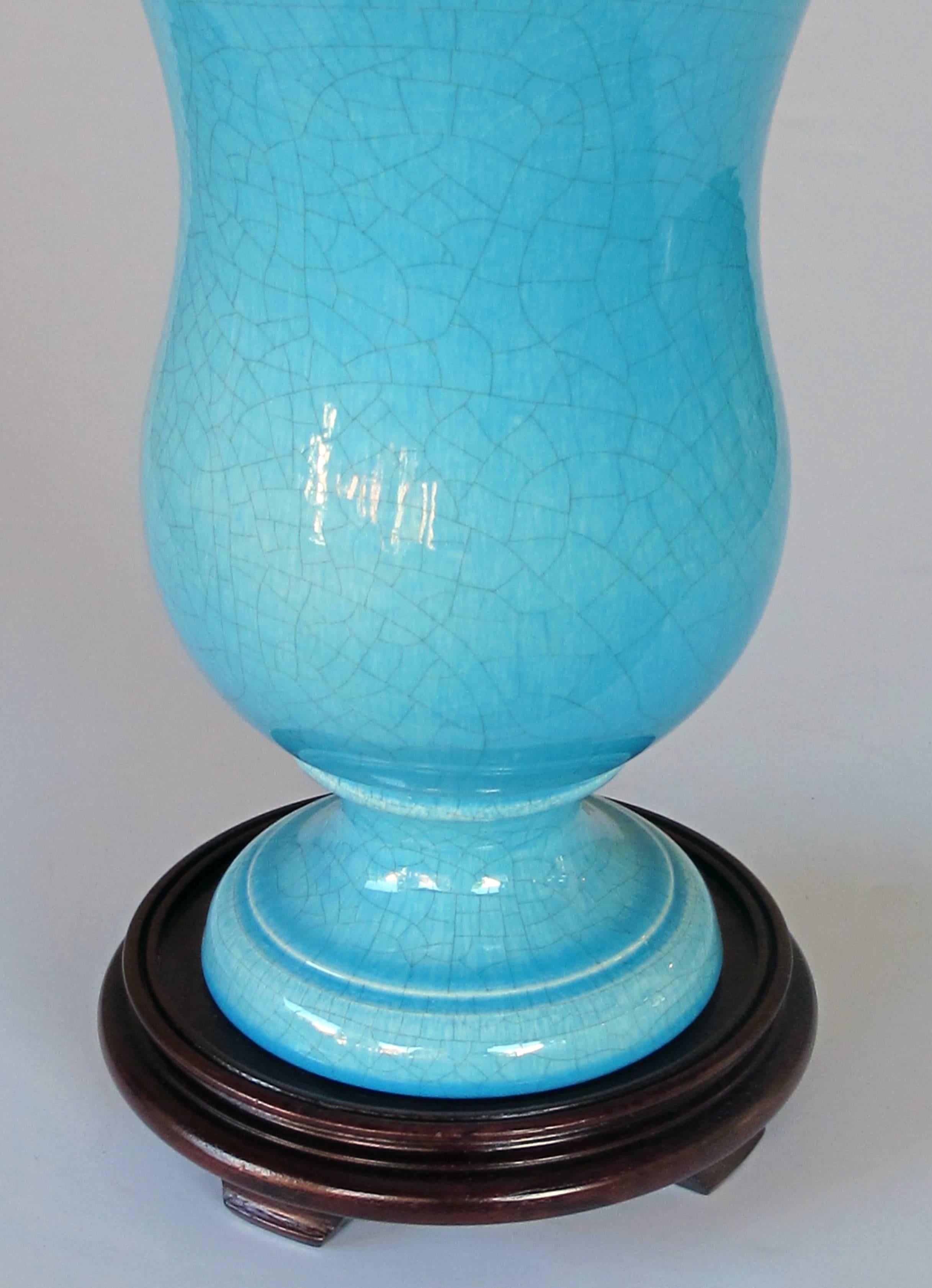 A striking and robust pair of French Art Deco turquoise crackle-glazed urns now mounted as lamps; each large-scaled urn with sweeping flared neck tapering to a flared foot; now drilled with later wooden mounts.