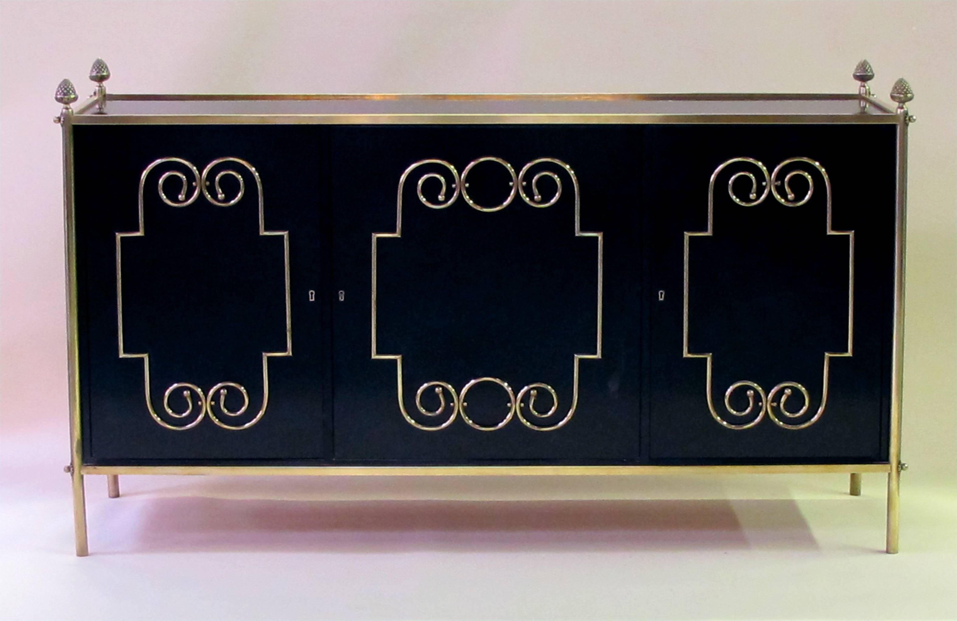 An exquisite American midcentury custom-made black lacquer three-door sideboard/buffet with applied brass scroll work; by Daniel Jones, Inc., New York; truly a one-of-a-kind, chic server with rectangular inset top within a solid brass border adorned