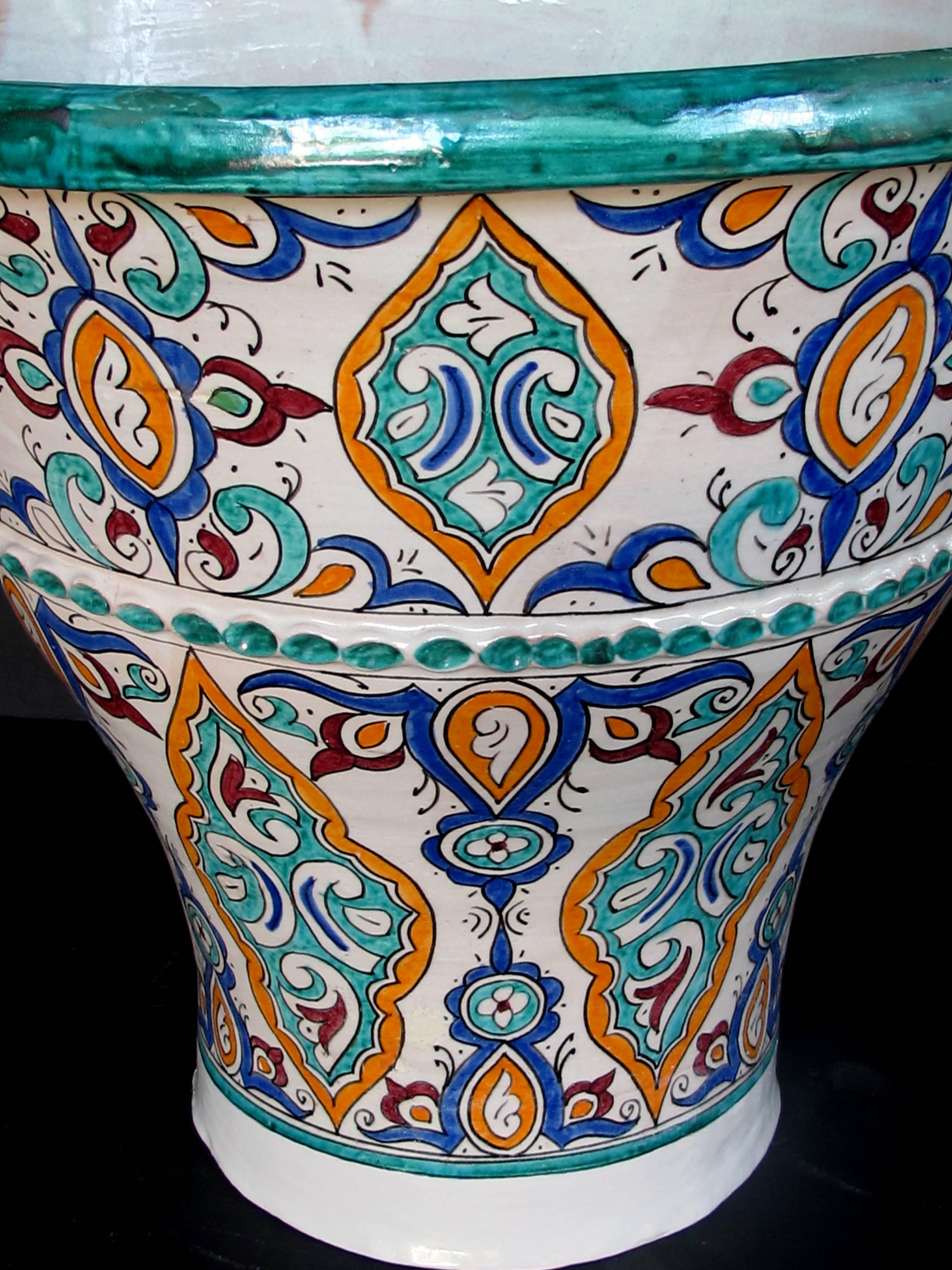 A large and vibrantly-glazed pair of Moroccan conical-form double-handled pots; purchased in Fez, Morocco; from the collection of a notable Napa interior designer for his hacienda in La Penita de Jaltemba, Mexico.
