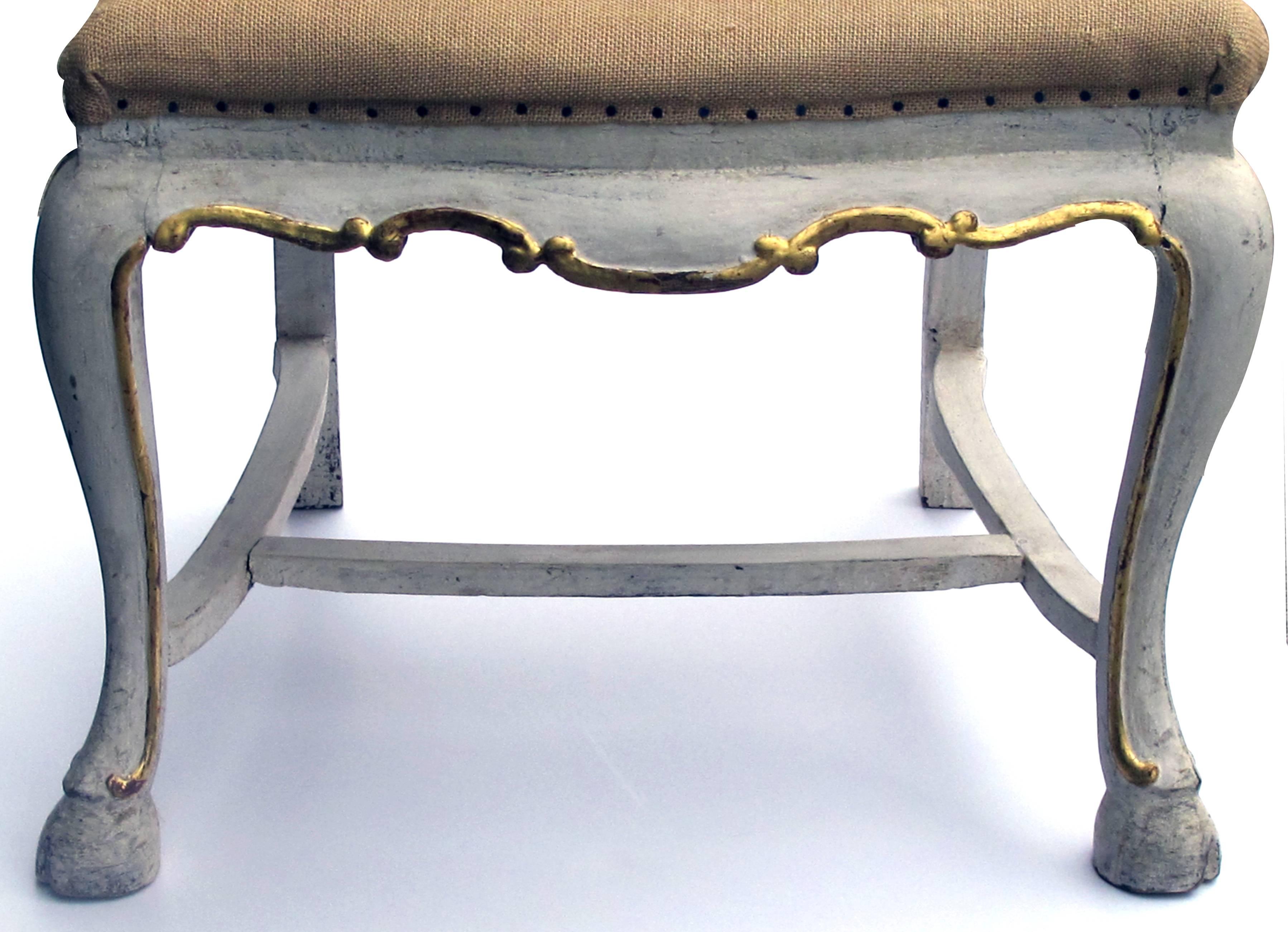 A shapely set of five Portuguese Rococo ivory painted and parcel-gilt side or dining chairs; priced individually; each with arching scrolled crest above a vasi-form splat and burlap-covered seat; raised on shapely cabriole supports ending in a