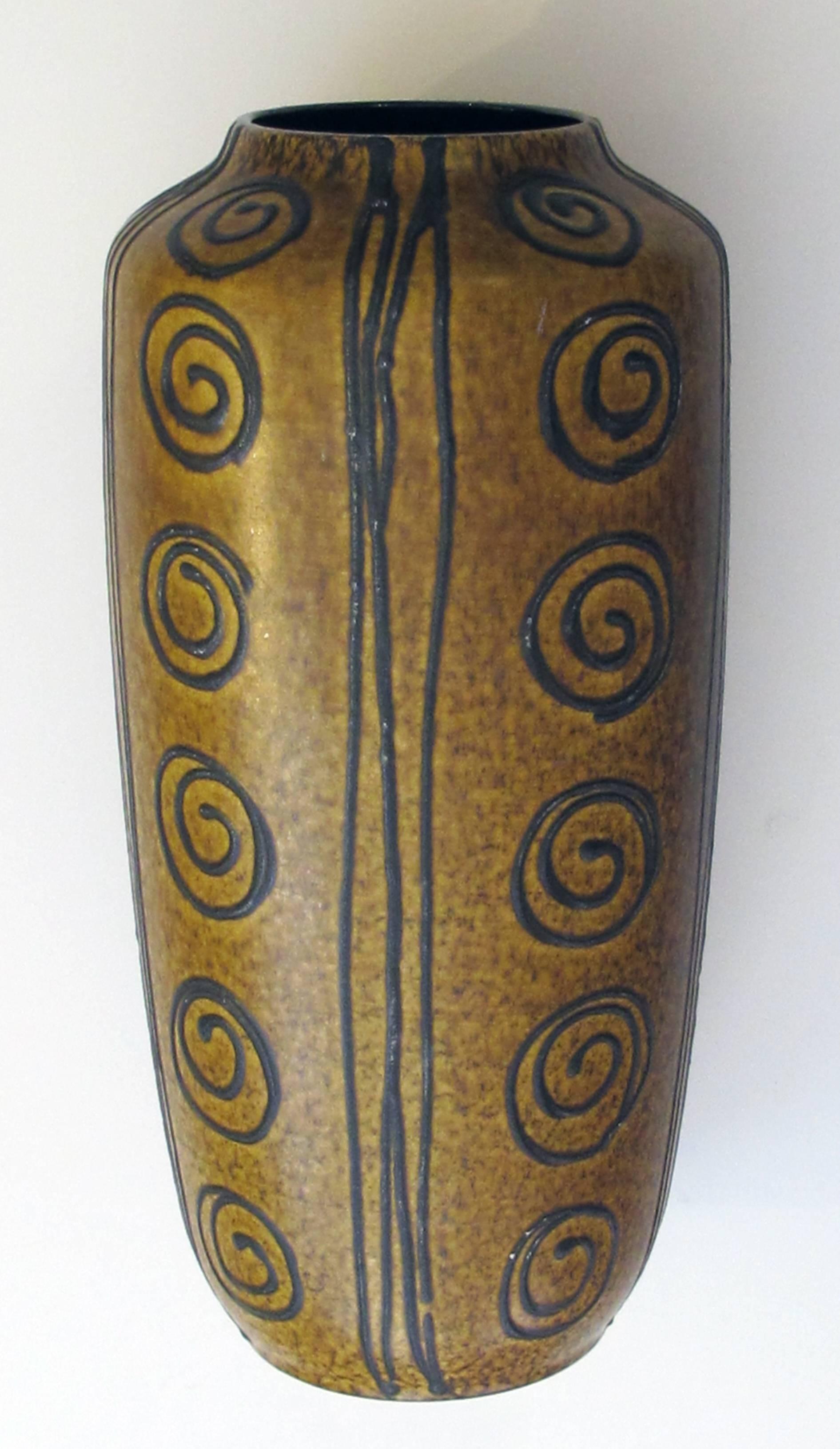 A tall and striking West German, 1960s ochre glazed vase with dark brown drip-glaze decoration; the tall tapering vase with everted mouth; adorned overall with dark brown drips and coiled spheres on an ochre ground; with maker's mark on underside.