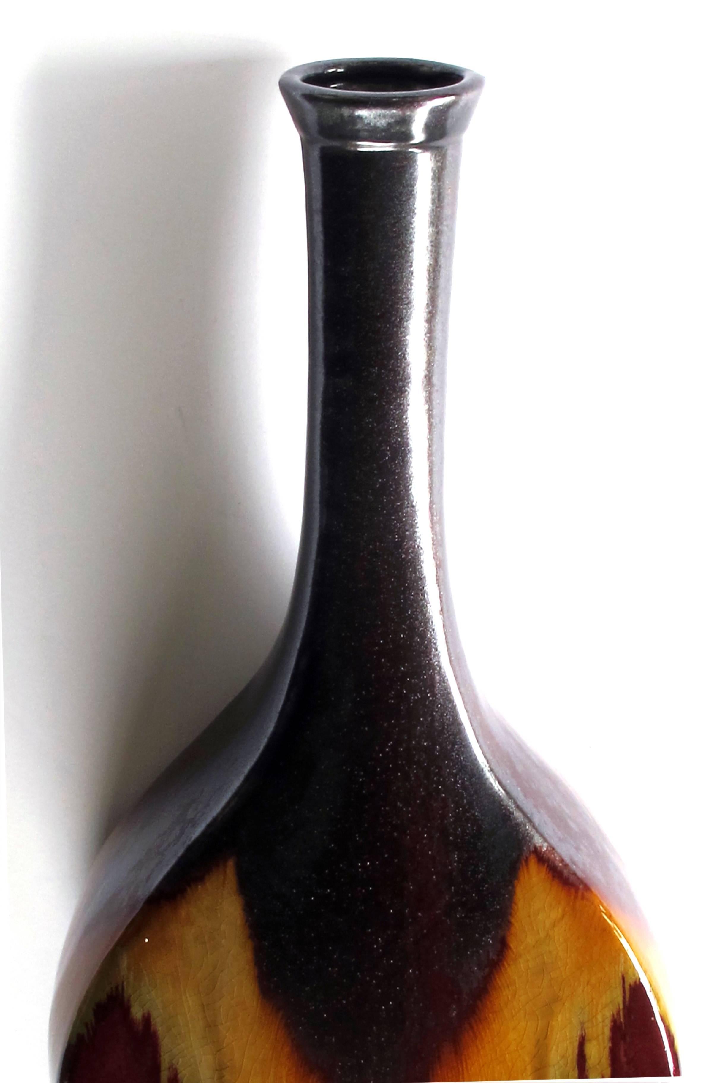 With long flaring neck of deep brown raku glaze over a bulbous body with russet and ochre drip glaze; fine craquelure overall.