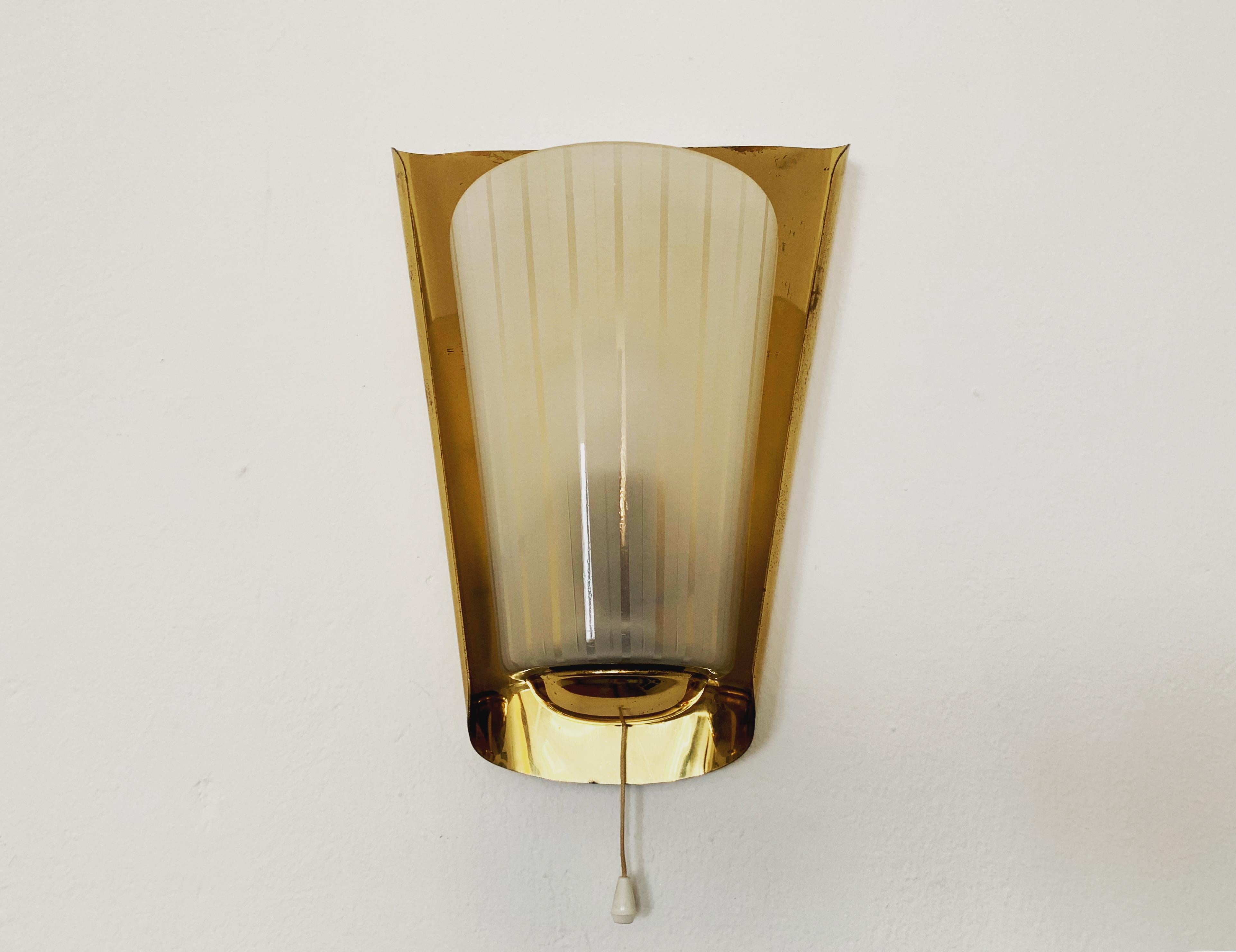 Lampada da parete molto bella degli anni '1950.
Forma molto elegante e classica.
La diffusione della luce è particolarmente bella grazie al vetro acidato e alla speciale bordatura in ottone.
Sulla parete si crea un cono di luce molto