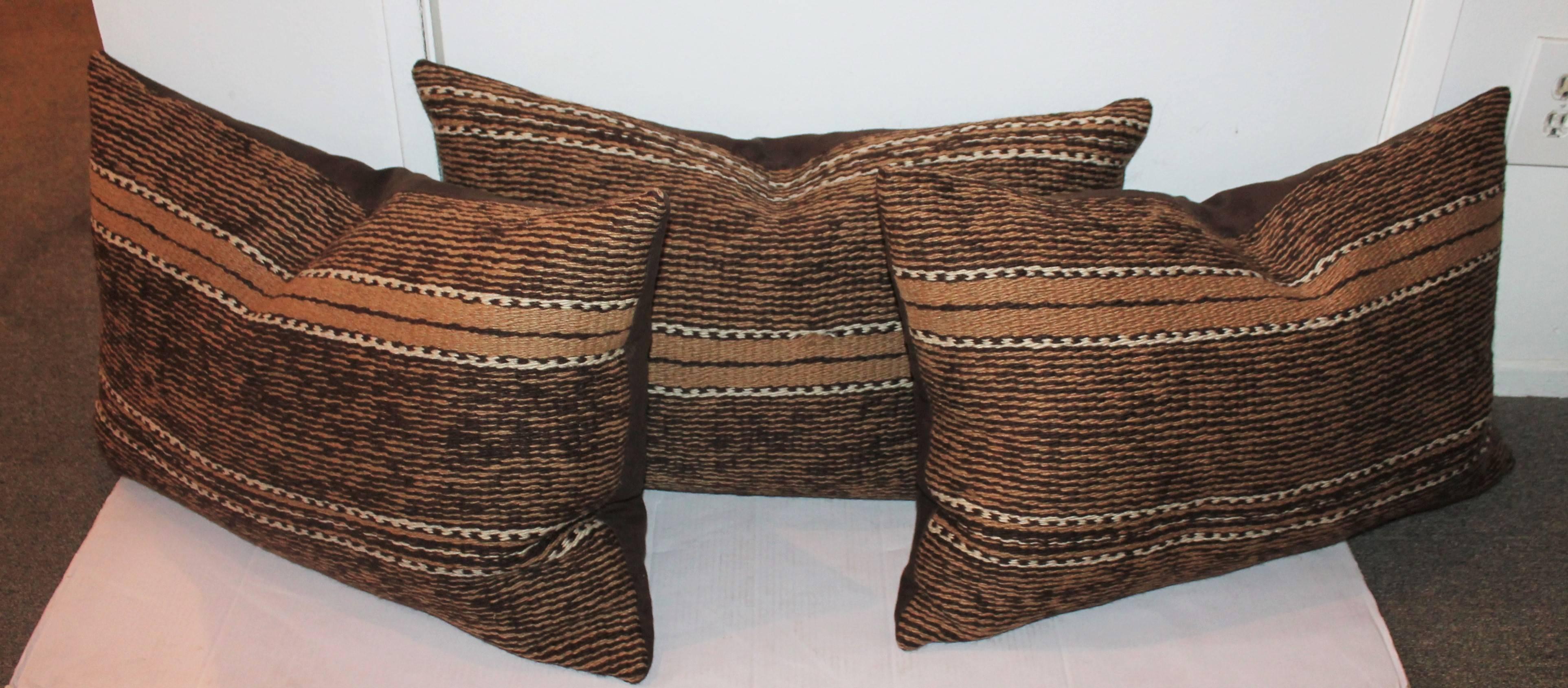 These handwoven pillows are from a large saddle blanket. The weaving is in great as found condition and has brown cotton linen backing. Sold as a group of three.