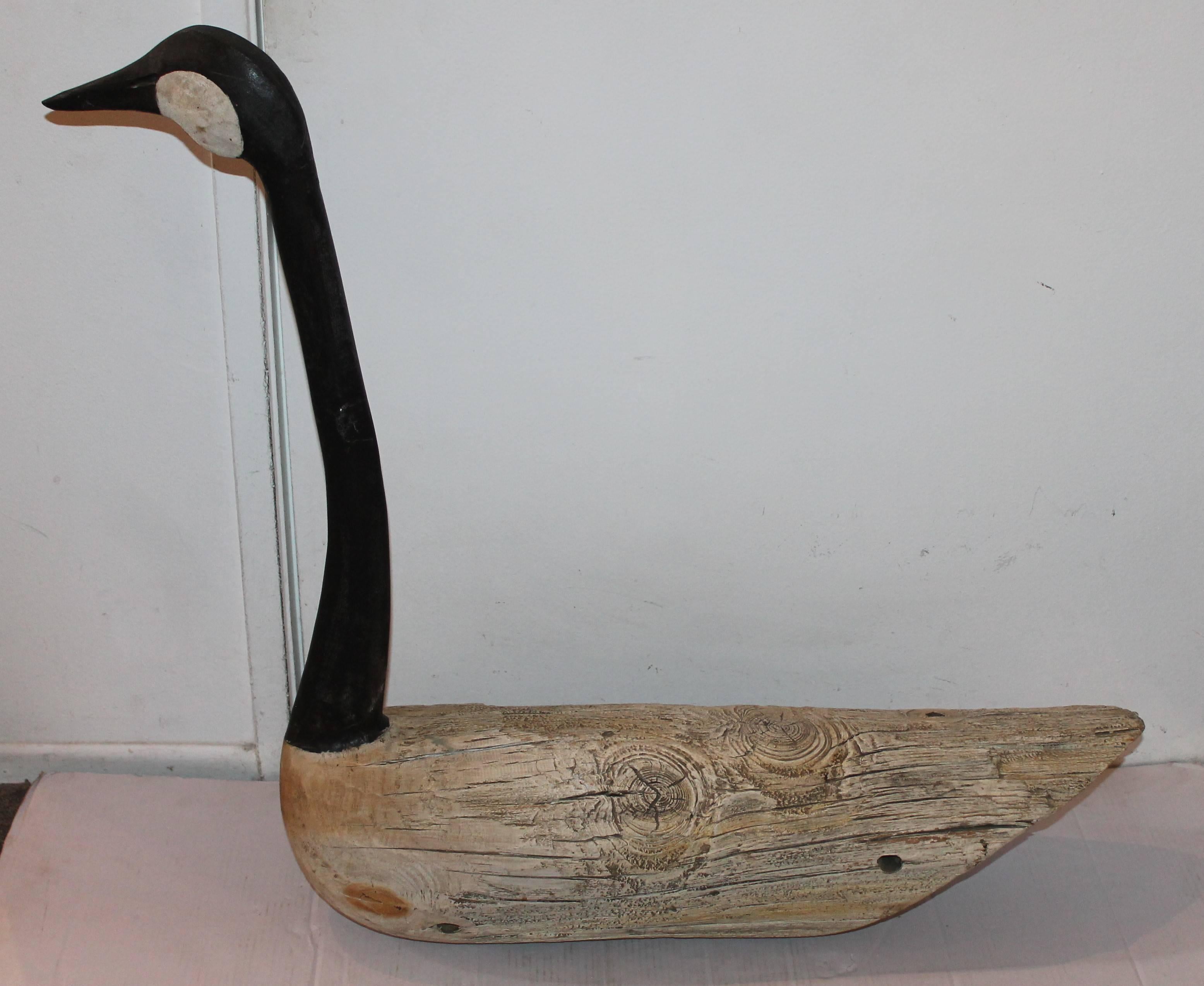 1930s log goose decoy, made from a log and the neck and head are hand-carved to fit the log. The neck is painted and has amazing patina body also has amazing patina created by age and use. There are incisions in the body where a rope would be