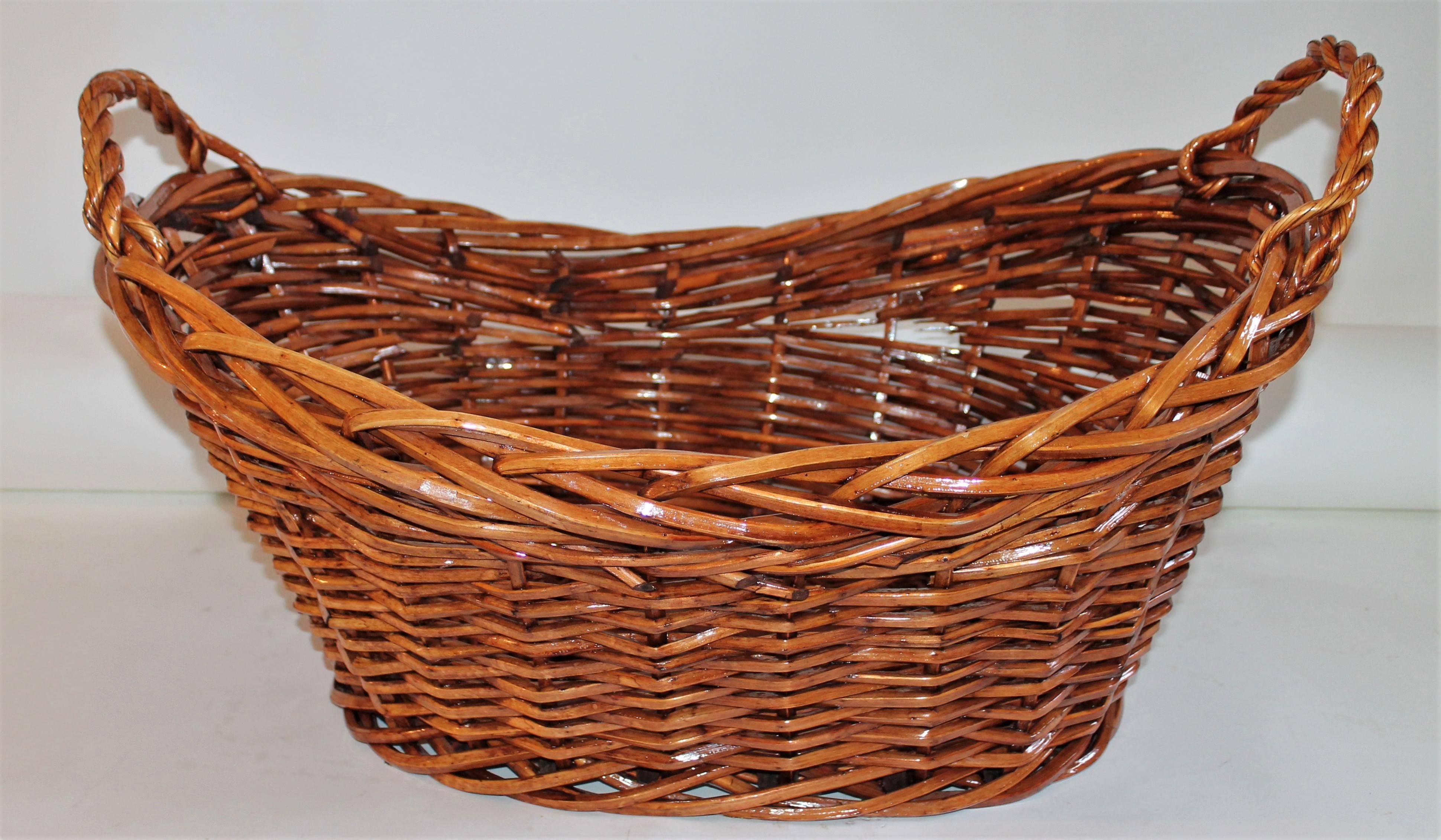 This willow laundry basket is in good condition and quite unusual shape. It has a stained varnish finish. This hand woven basket has a western or cabin look to it.