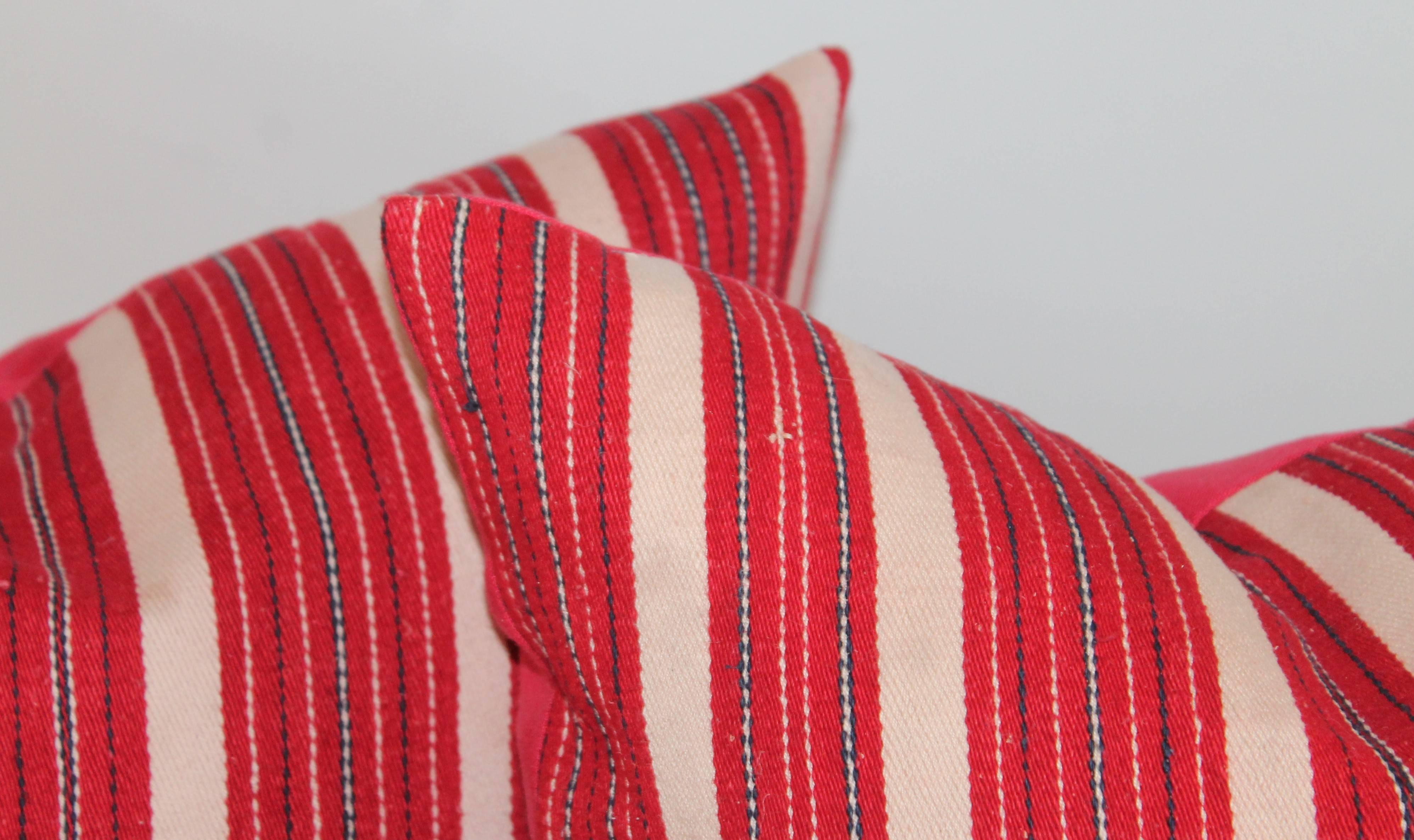 These interesting cotton red and white ticking pillows have red cotton linen backing. The inserts are down and feather fill. Two pairs in stock.