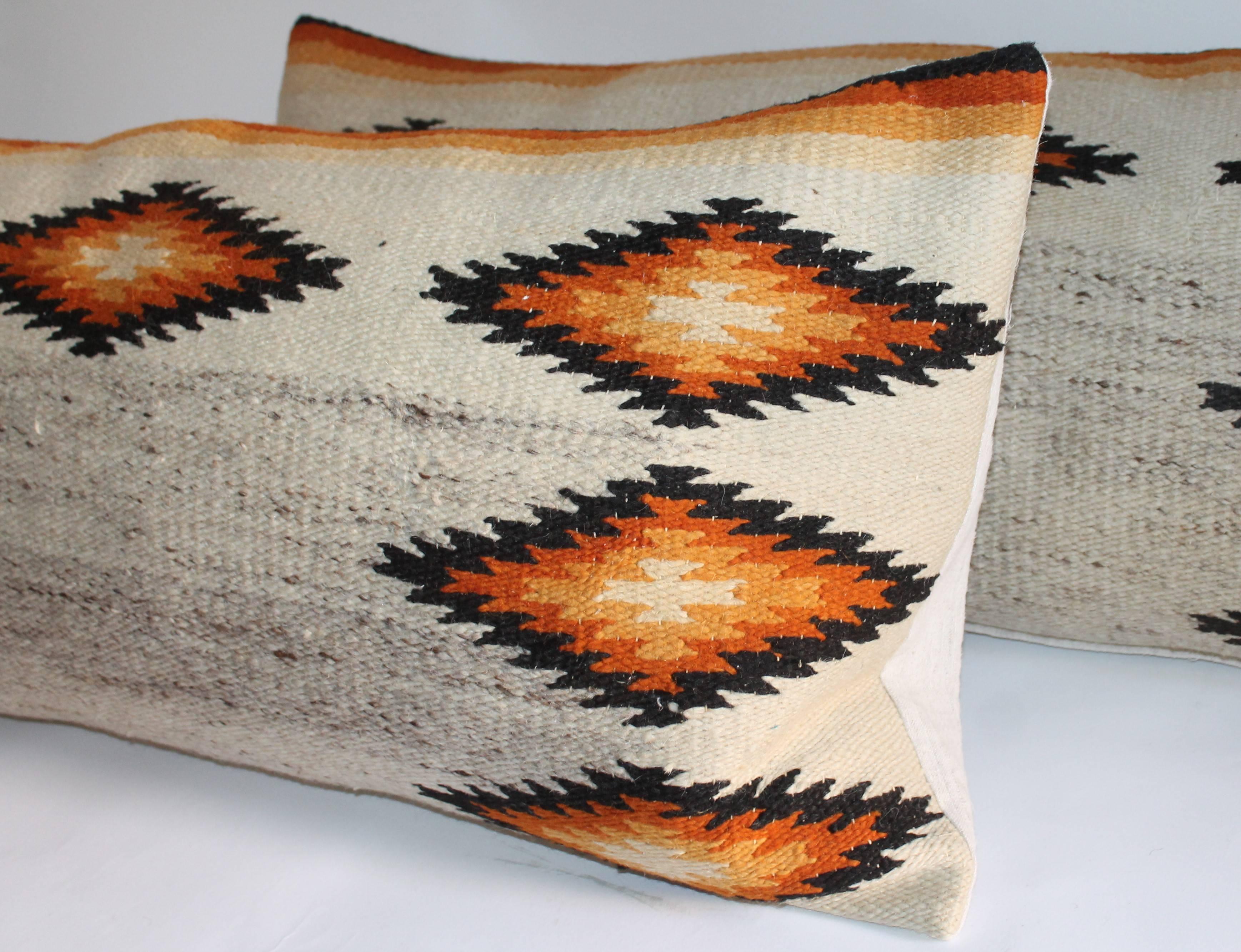 These large geometric gold and black Navajo Indian weaving bolster pillows are in great condition. The pattern is like a Indian sunset. The backings are in cotton linen fabric. The inserts are down and feather fill.