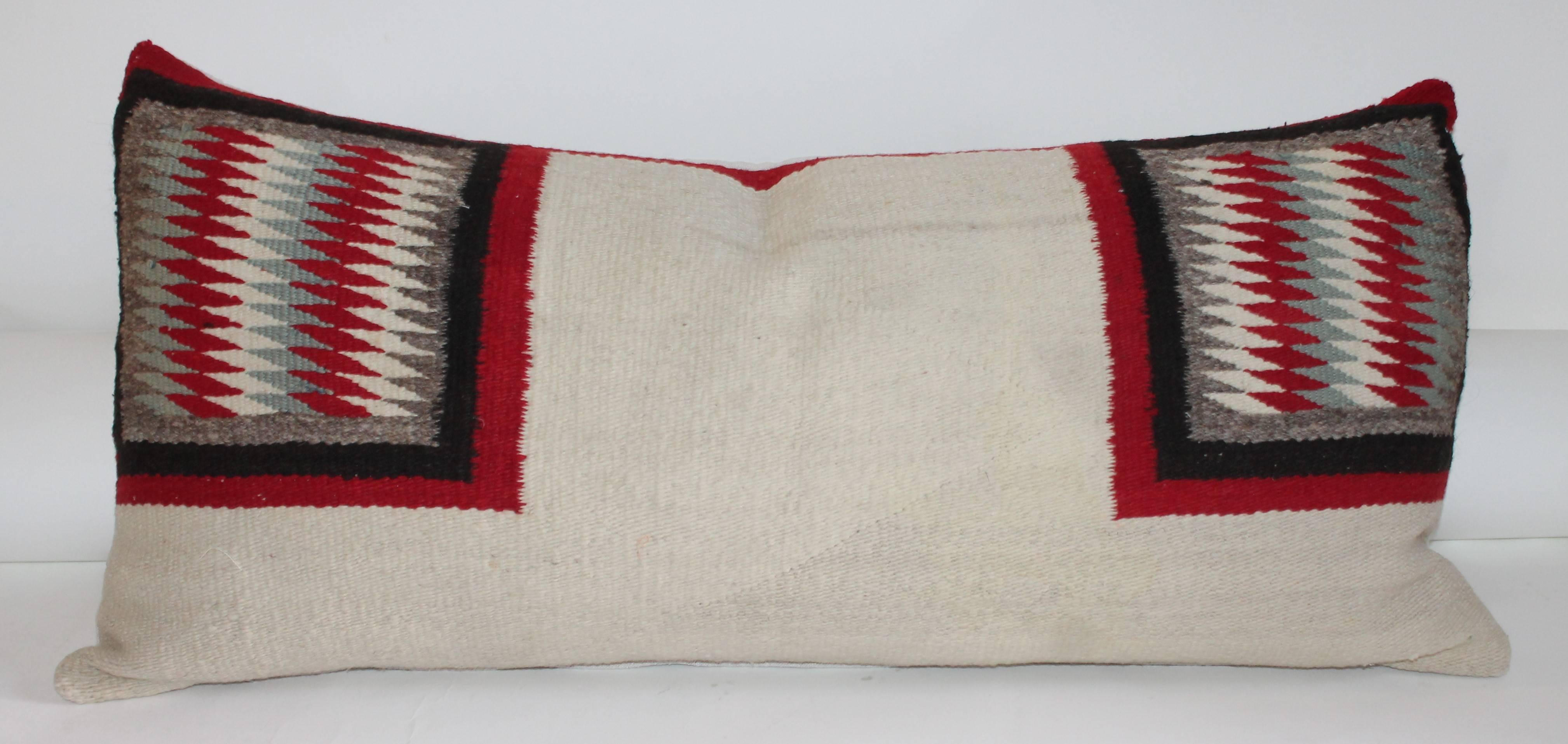 This saddle blanket weaving bolster pillow is in great as found condition with geometric squares on each end. The condition is in very good. The backing is in homespun linen.
