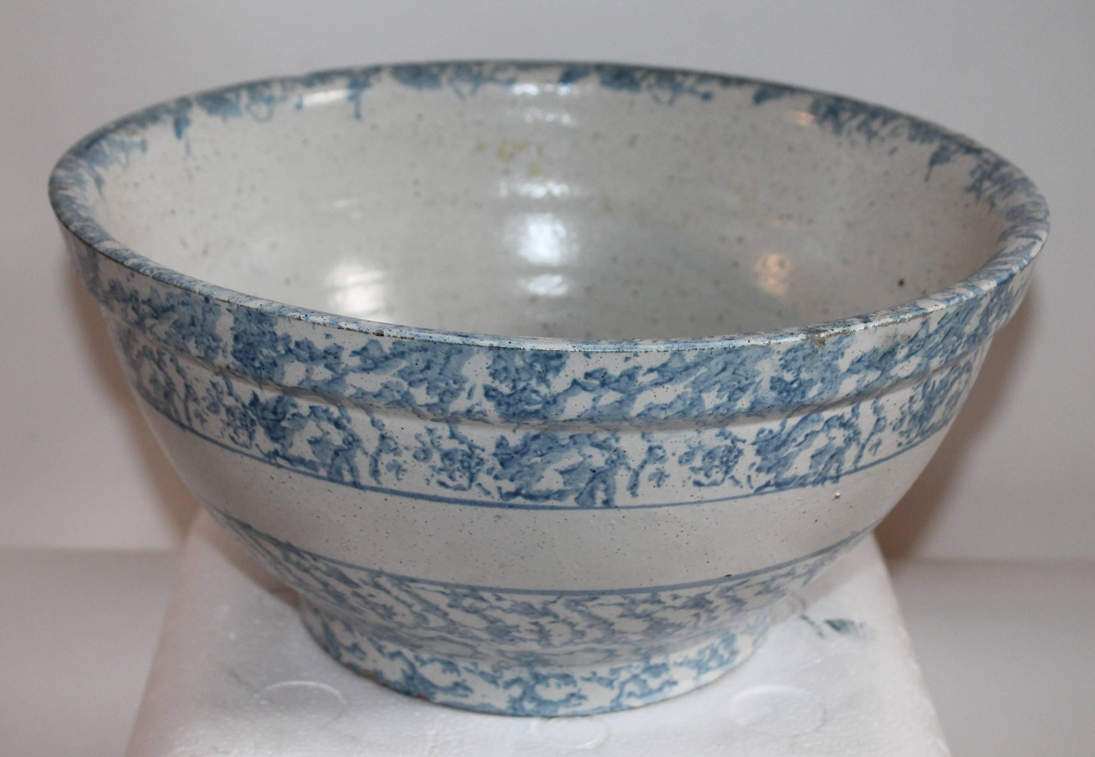 This large banded sponge ware pottery mixing bowl is in a light sky blue sponged pattern. The rim has some minor age chips and a small spider in the inside but not through the bowl. This is a 13