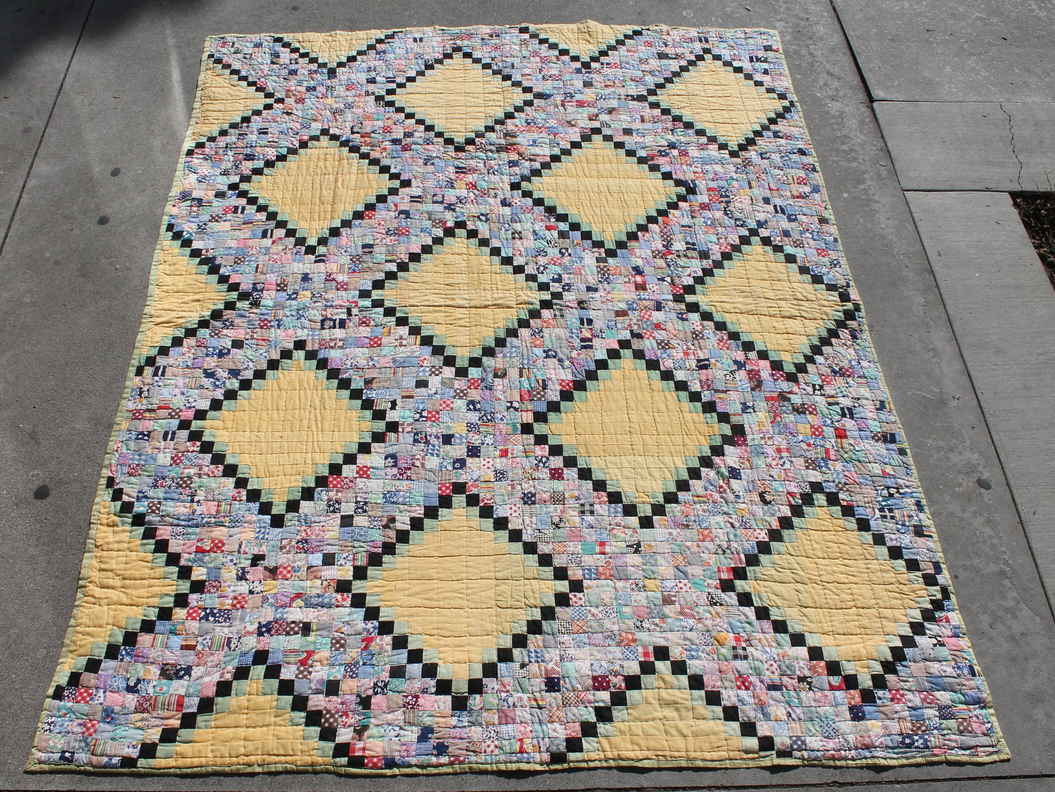 This tiny pieced postage stamp chain is in good condition. The yellow and green ground is a light nice shade. This quilt is comprised of floral feed sack fabrics.