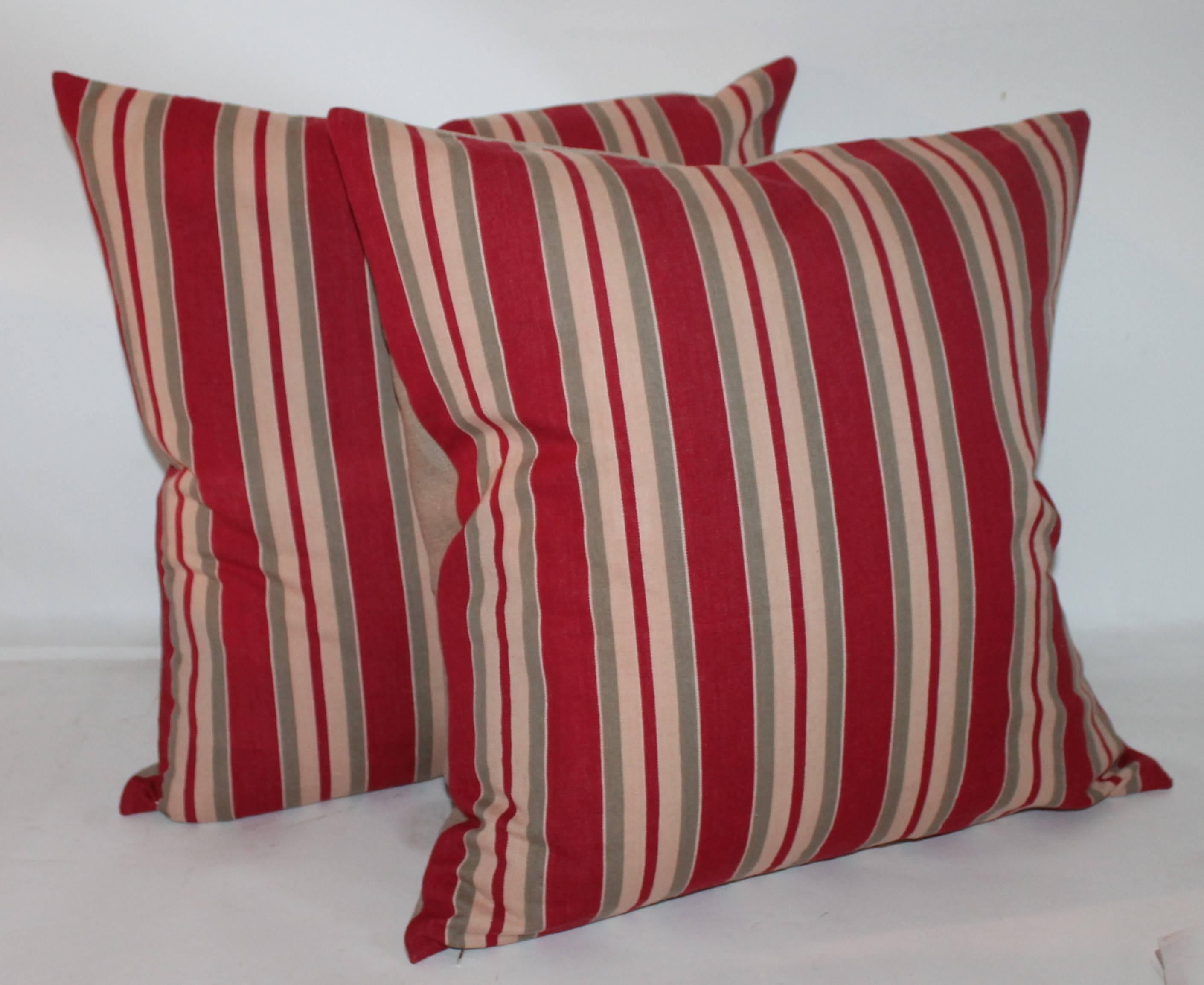These tan and red striped ticking pillows are in fine condition. The backings are in a cream cotton linen. Four pairs in stock 20 x 20 / 22 x 22.