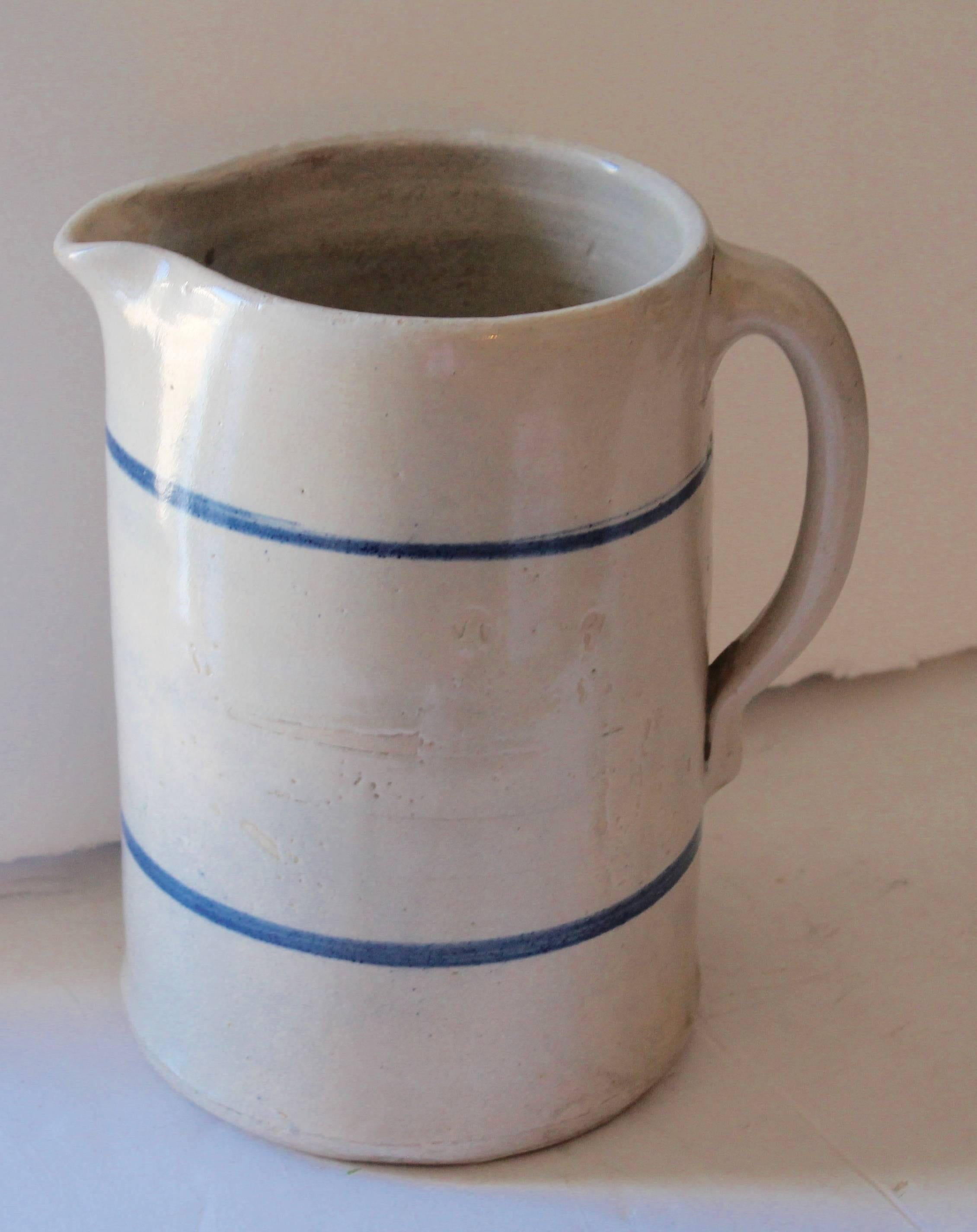 What a great looking country pitcher. This is a handmade and painted stoneware pitcher. With two simple lines in blue. The condition is very good.