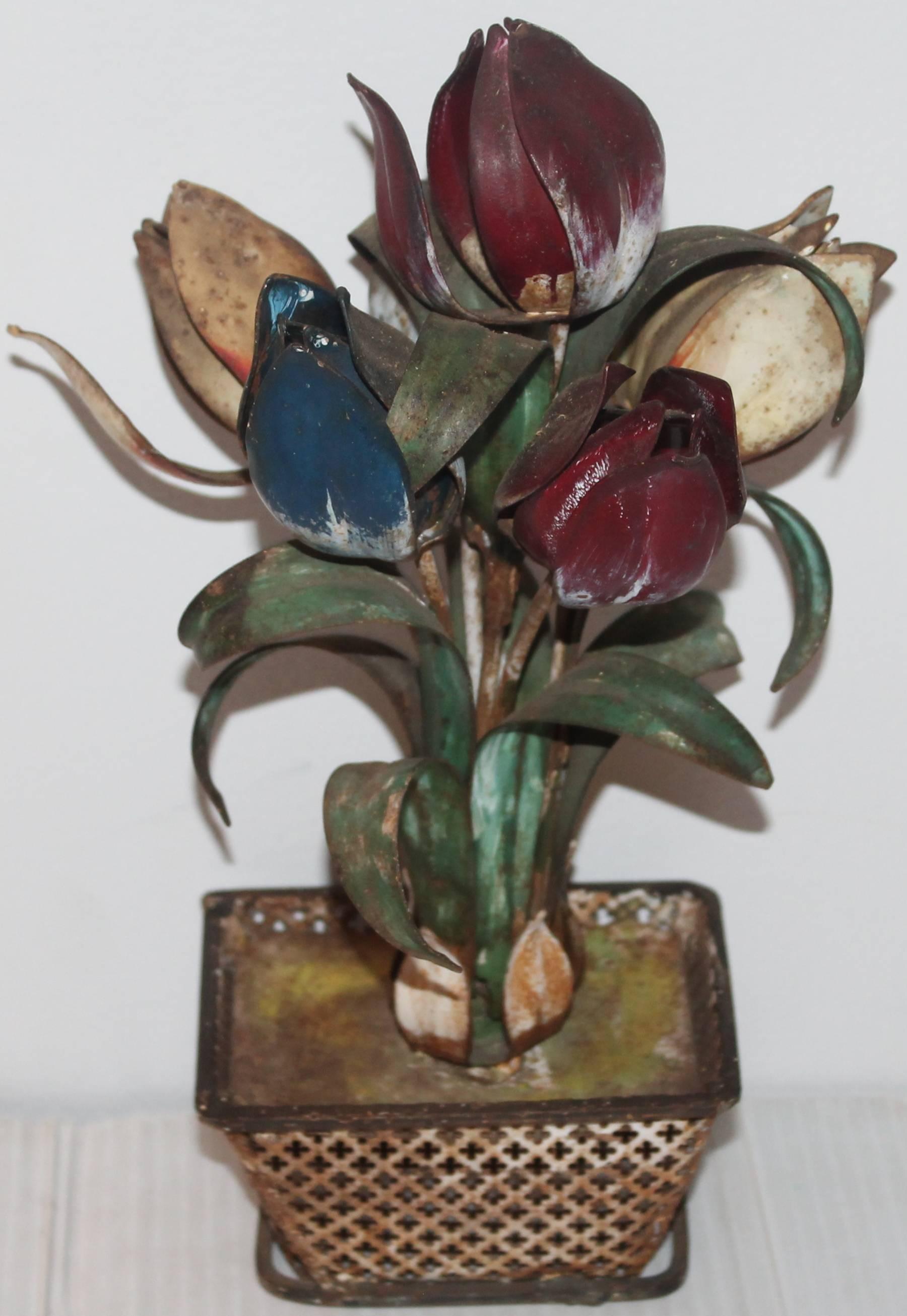This is the most unusual metal Folk Art arrangement of flowers in a urn in the form of a basket planter. The condition is very good. Great look on a mantel or bookshelf. Wonderful old worn surface. This late 19th century pot of flowers is in all