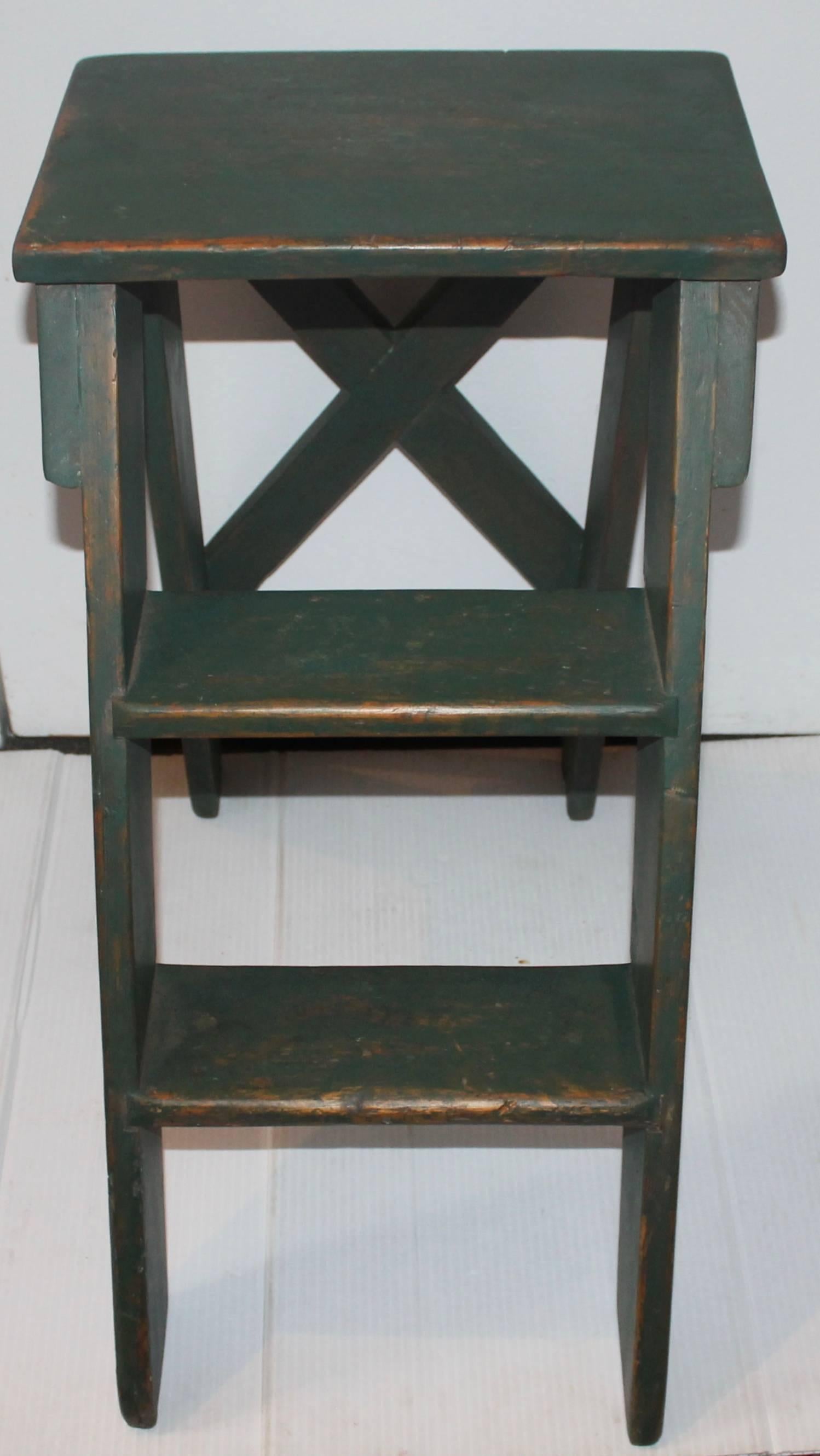 This original green painted 19th century step ladder is a stationary step ladder from New England. The condition is very strong and sturdy. The surface is worn but a wonderful patina.