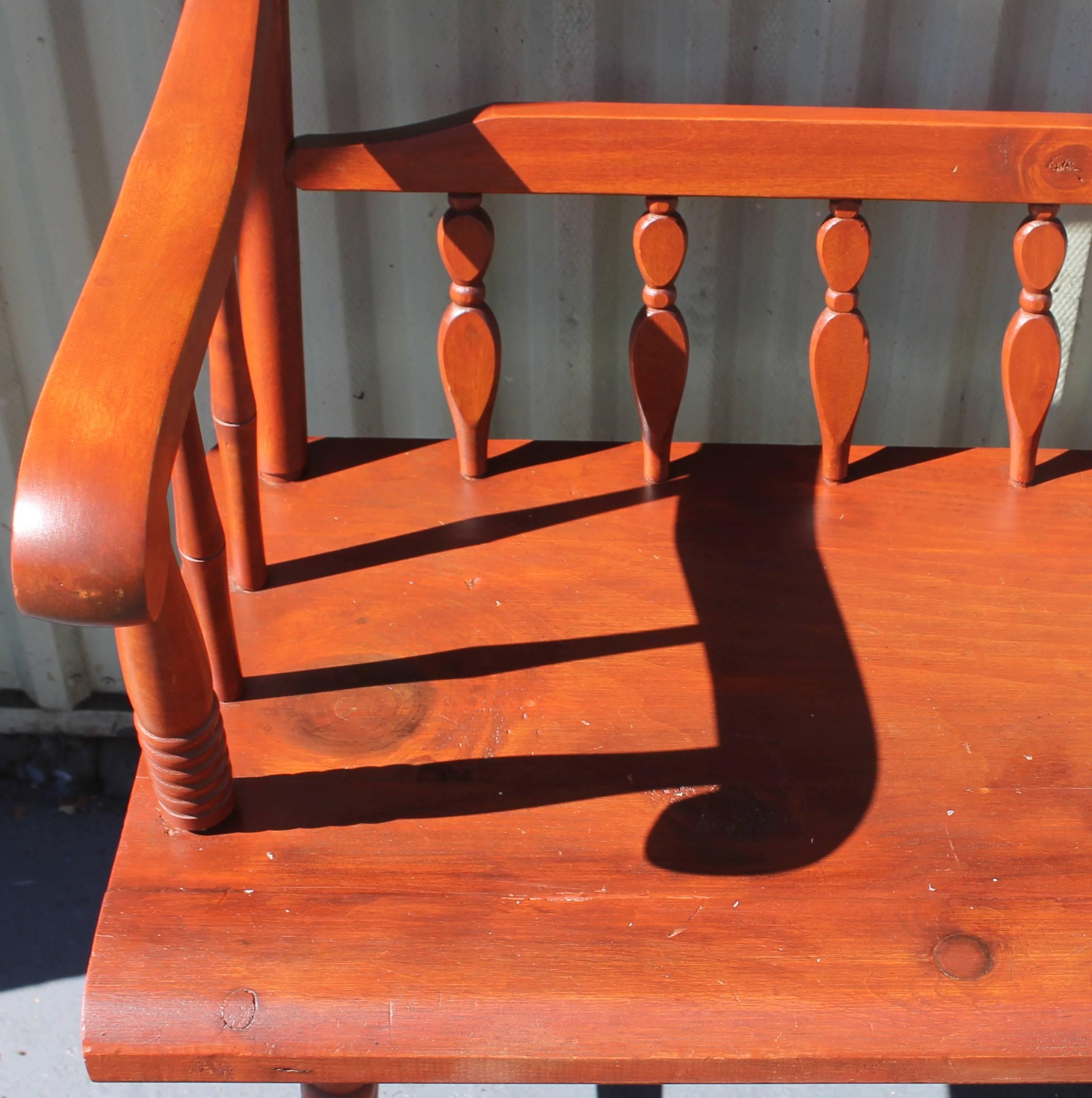This wonderful red wash painted bench from Pennsylvania has a super mellow patina. This bench or settle is in very good sturdy condition. The carving is wonderful and very detailed. Great in the entry of a home.