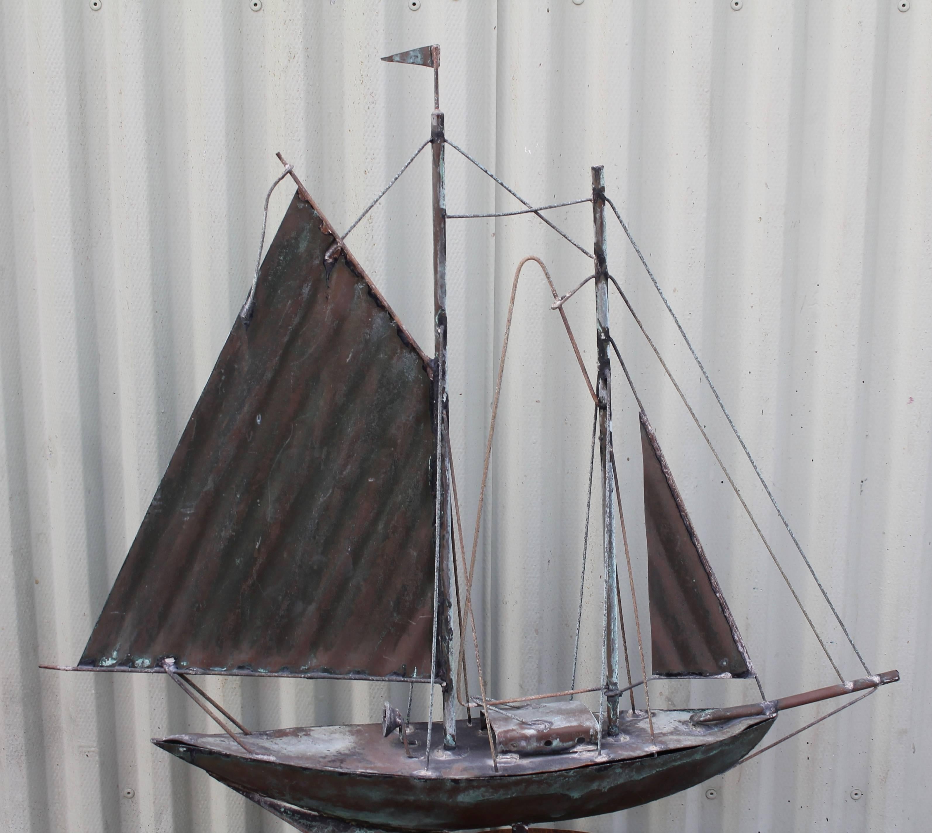 This wonderful copper sailboat weathervane is in good condition with a super verdigris surface. There are minor breaks in the mast ropes and only one flag flying. The condition is very good with wear consistent with age and use. This vane is on a