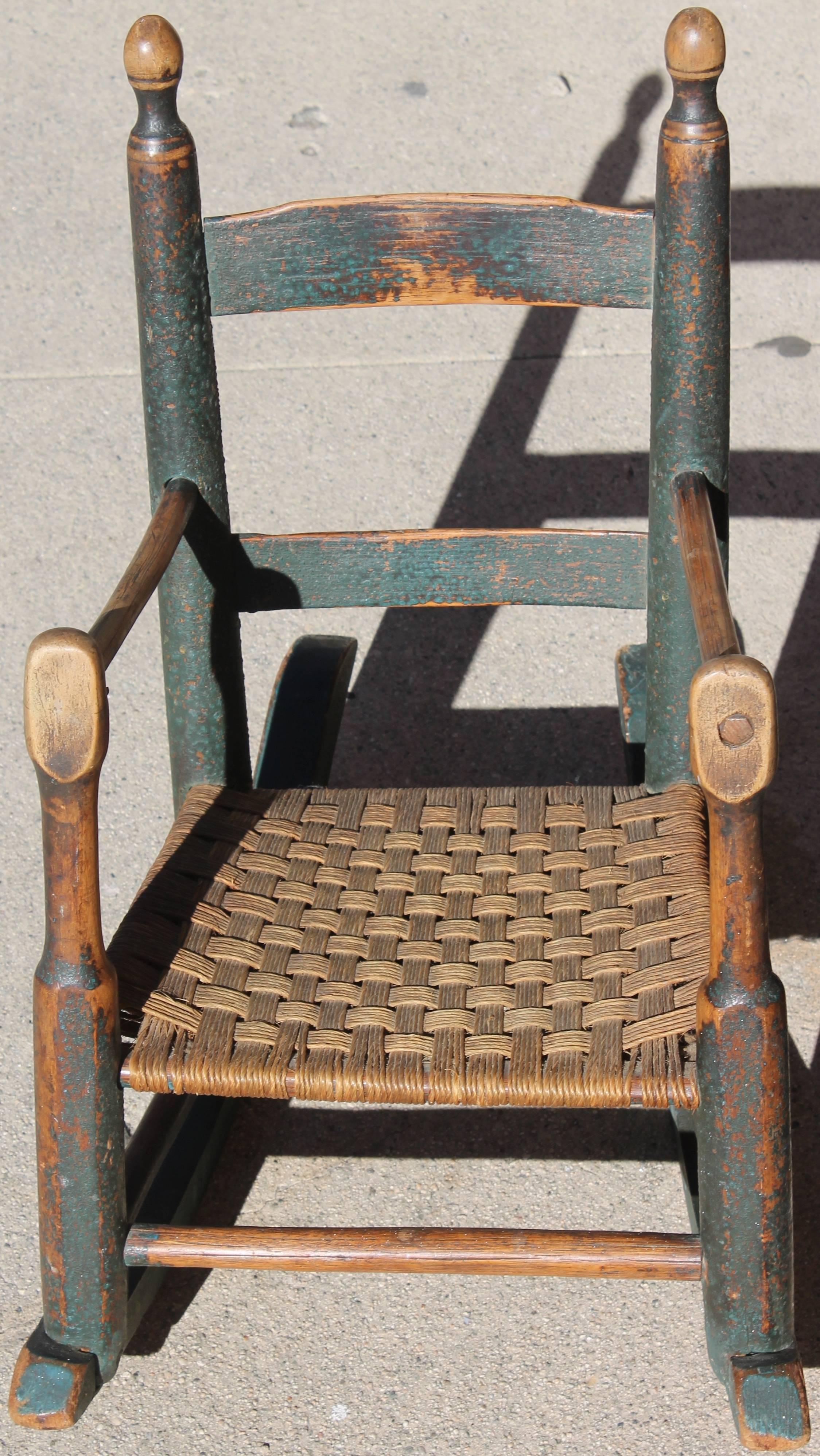 This is one of the best children's original painted rocking chair we ever seen. The undisturbed painted surface is the very best with wonderful worn patina. The seat is a old replaced handwoven hemp seat. Most early rockers or chairs have a second