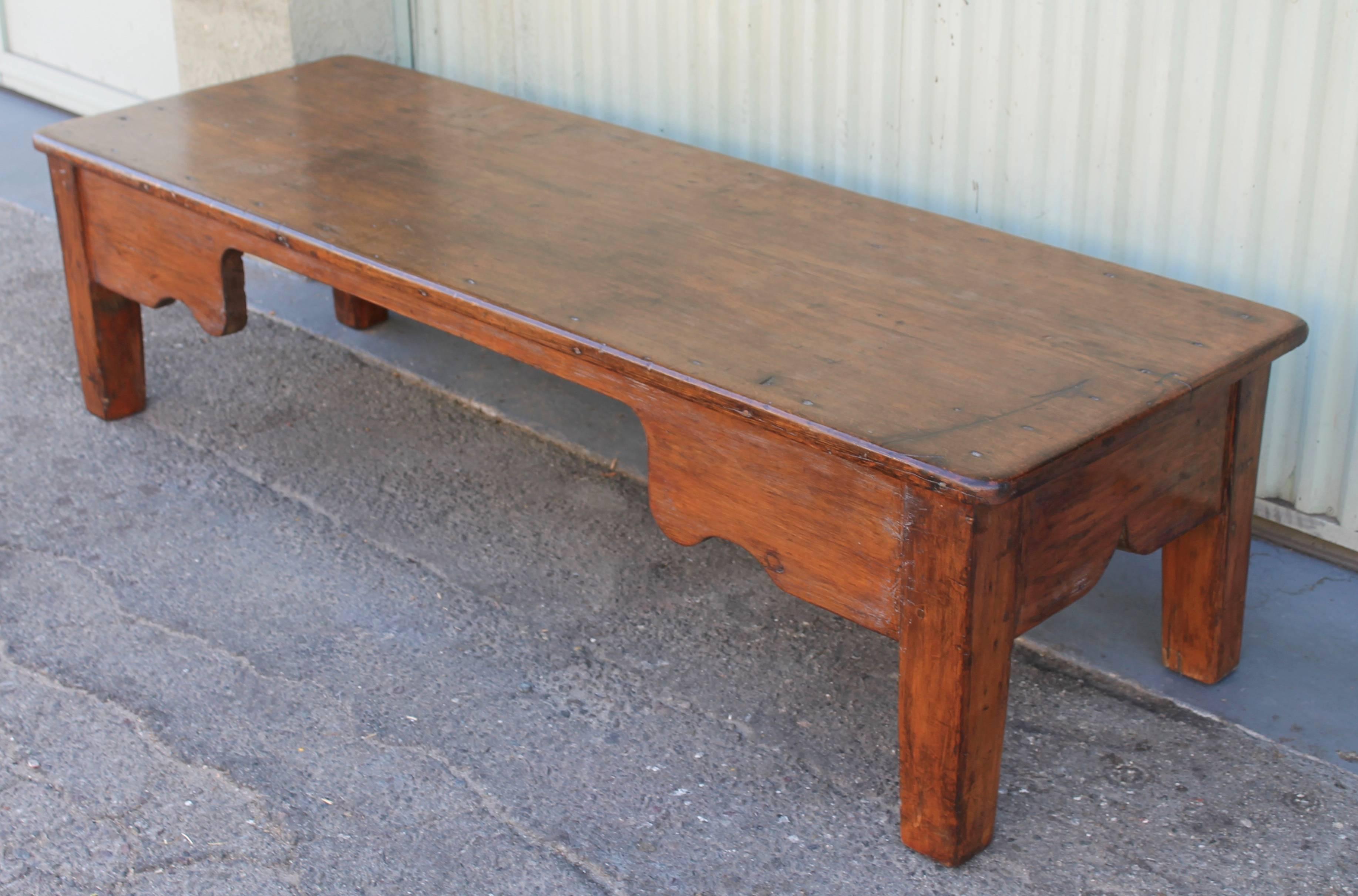 This is the most amazing large coffee table ever. It was a six foot long farm table at on time and now a wonderful Americana coffee table. It is made from wide pine plank boards and large hand cut square nails. The feet are square and thick. This