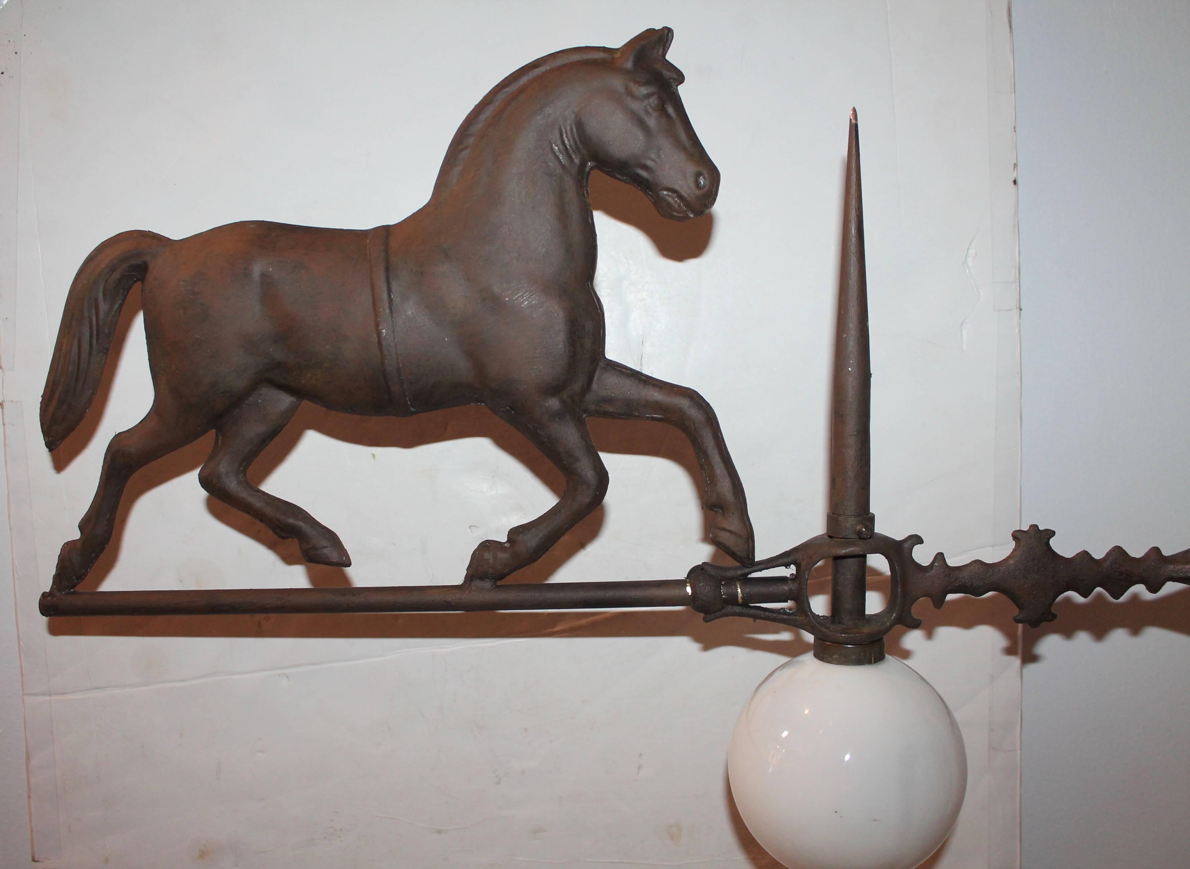This Folk Art horse is painted copper and iron Directional is all original and has the iron and brass staff. The milk glass ball is original as well. The vane is on a custom-made cast iron stand. The condition is very good.