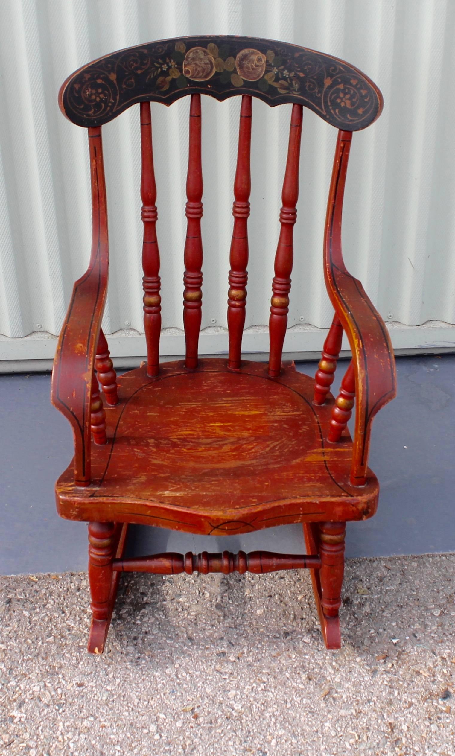 Amazing 19th century red painted rocking chair with wonderful painted floral decorated backrest. The arms are flat and bentwood. Condition is very. It is in very good condition.