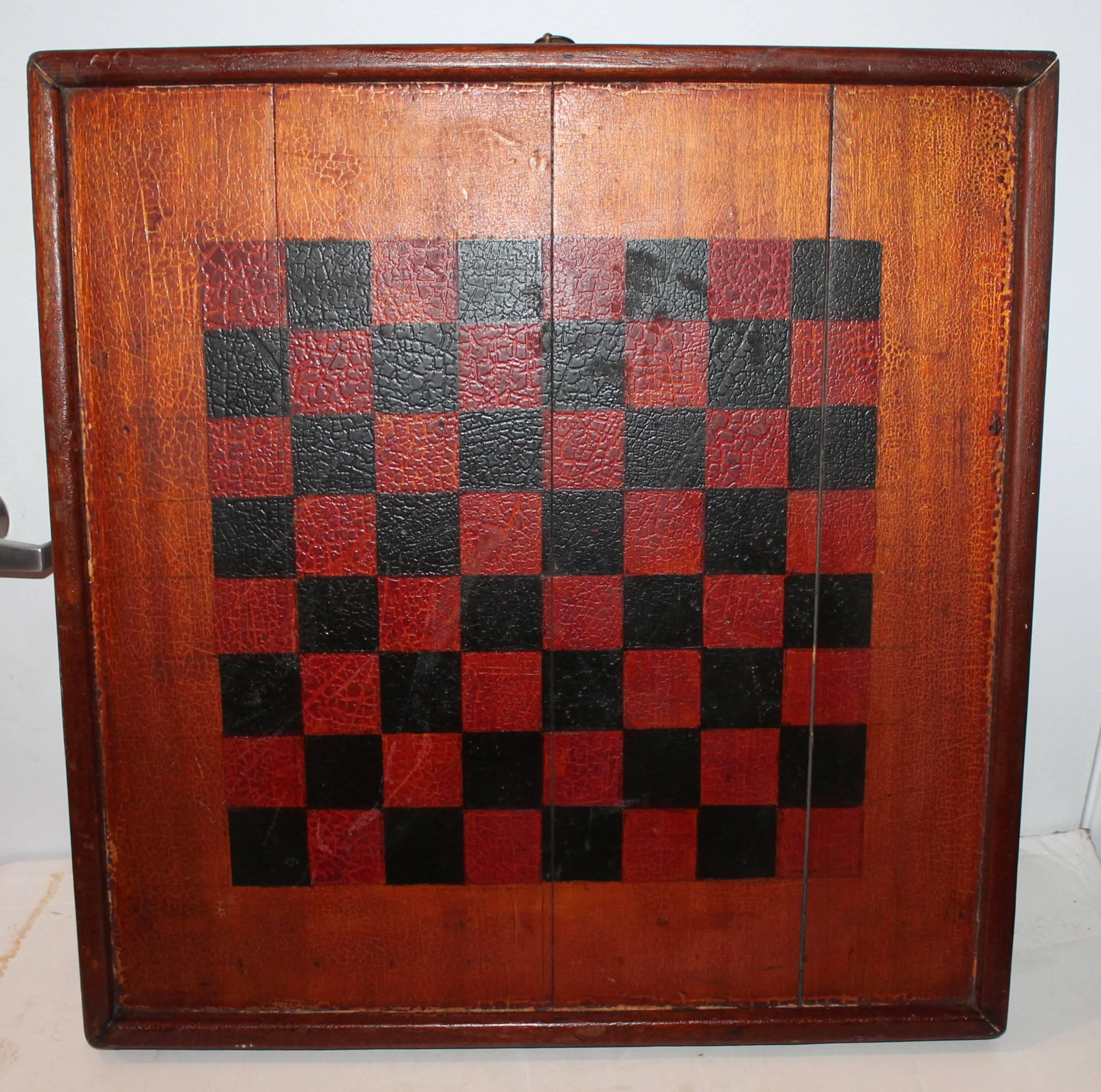 This double-sided original painted monumental Chinese checkers and checker board in one has a spectacular grungy undisturbed surface. This thick board has the original brass hanger on top. The condition is very good. This is a one of a kind handmade